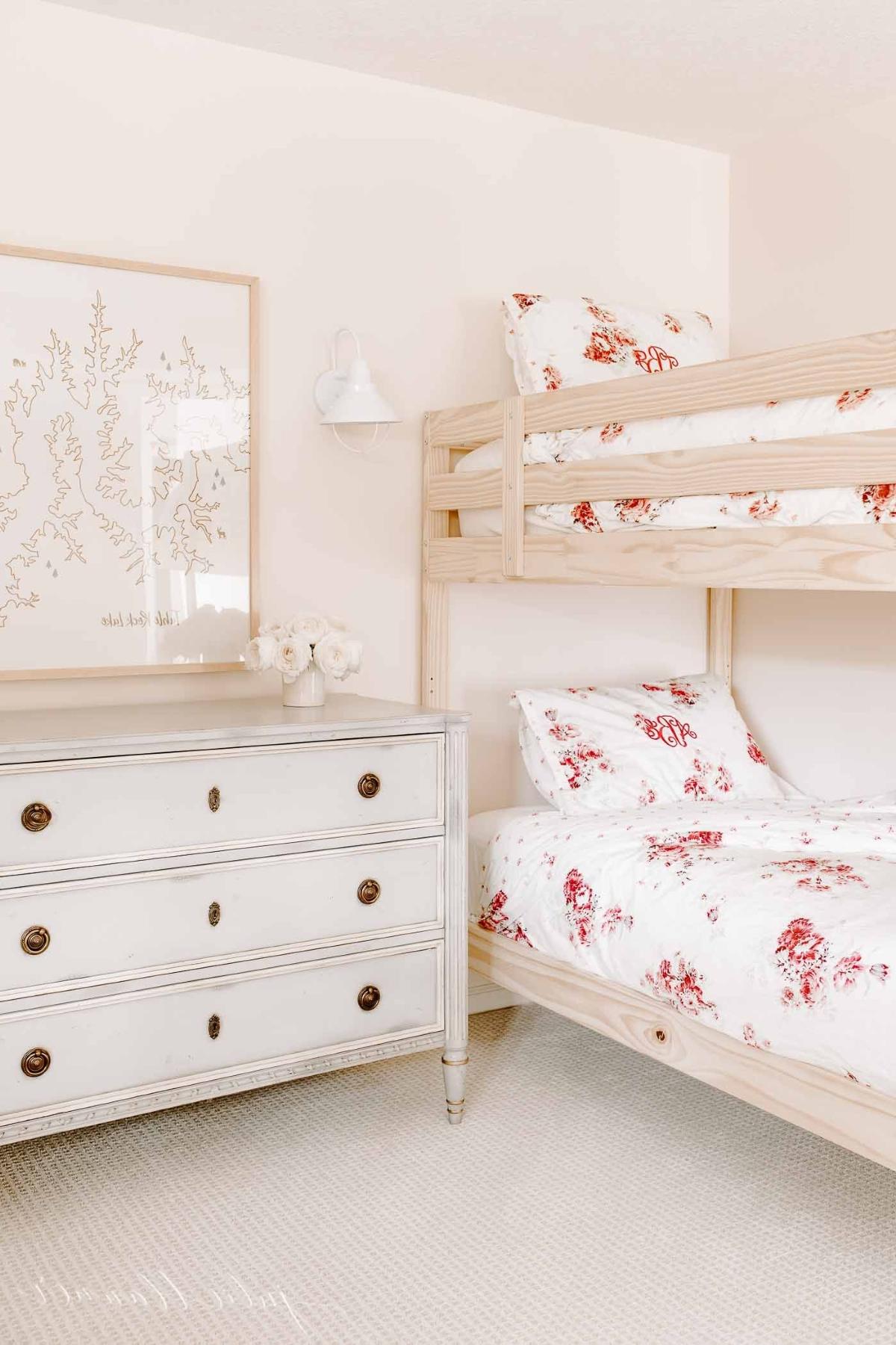 Mädchenetagenbett 2 Mädchen-Etagenbetten mit floraler Bettwäsche in einem rosa Schlafzimmer.