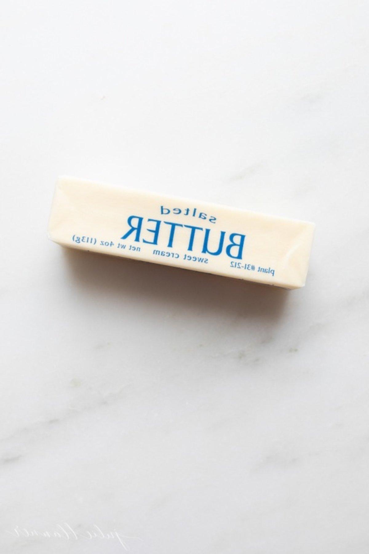 Ein einzelnes Stück gesalzene Butter auf einer Marmorarbeitsplatte.