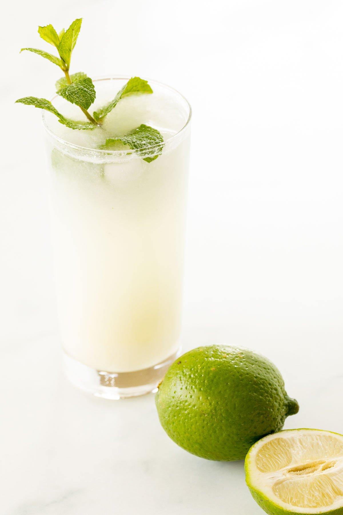 Kokosnuss-Mojito 2 Ein Kokos-Mojito, garniert mit Minze, auf einer Marmorfläche.