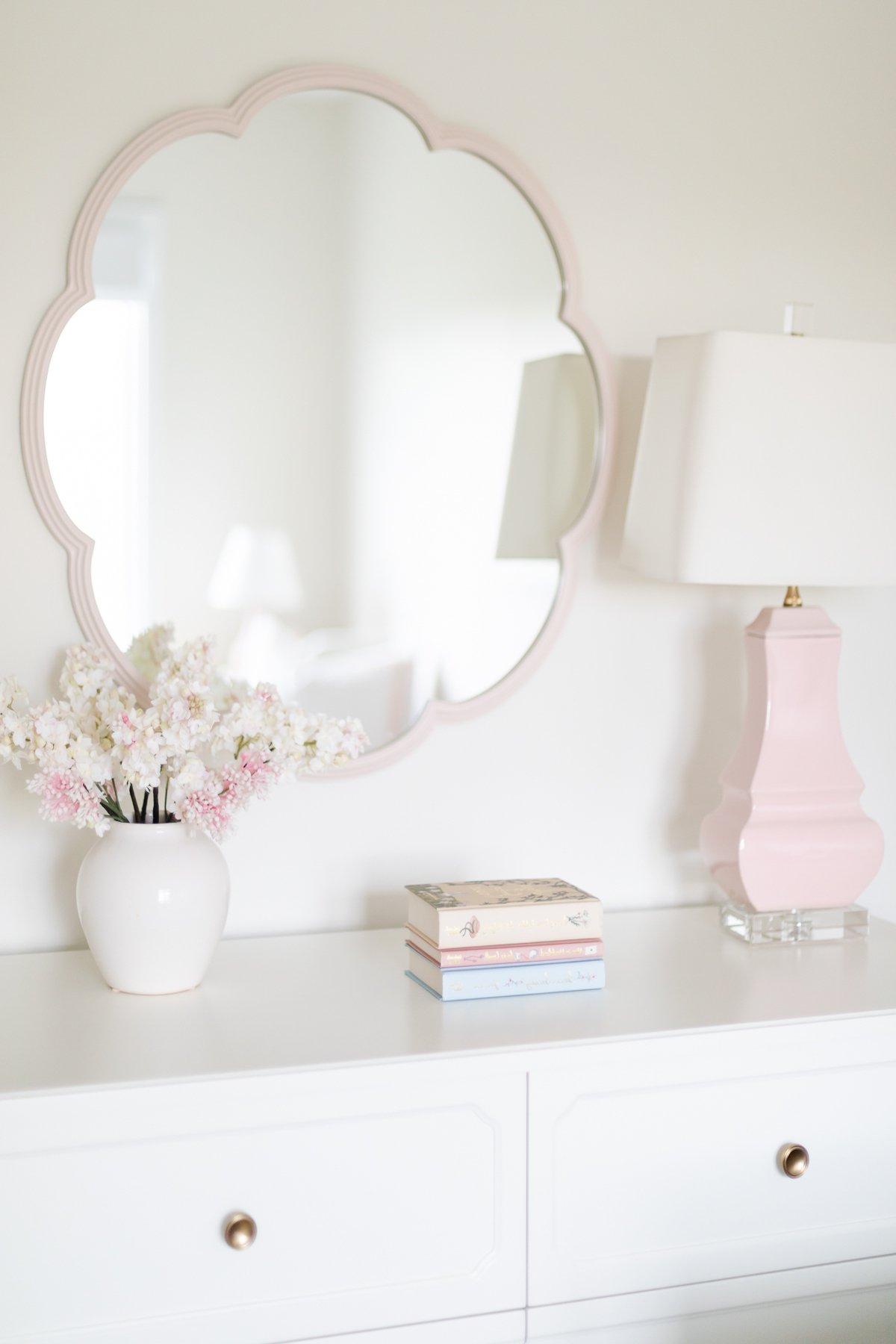Pottery Barn Kids: Der Look zum kleinen Preis 2 Eine weiße Kommode, liebevoll dekoriert mit rosafarbenen Blumen und einem passenden Spiegel darüber, der den Pottery Barn Kids Look for Less perfekt einfängt.