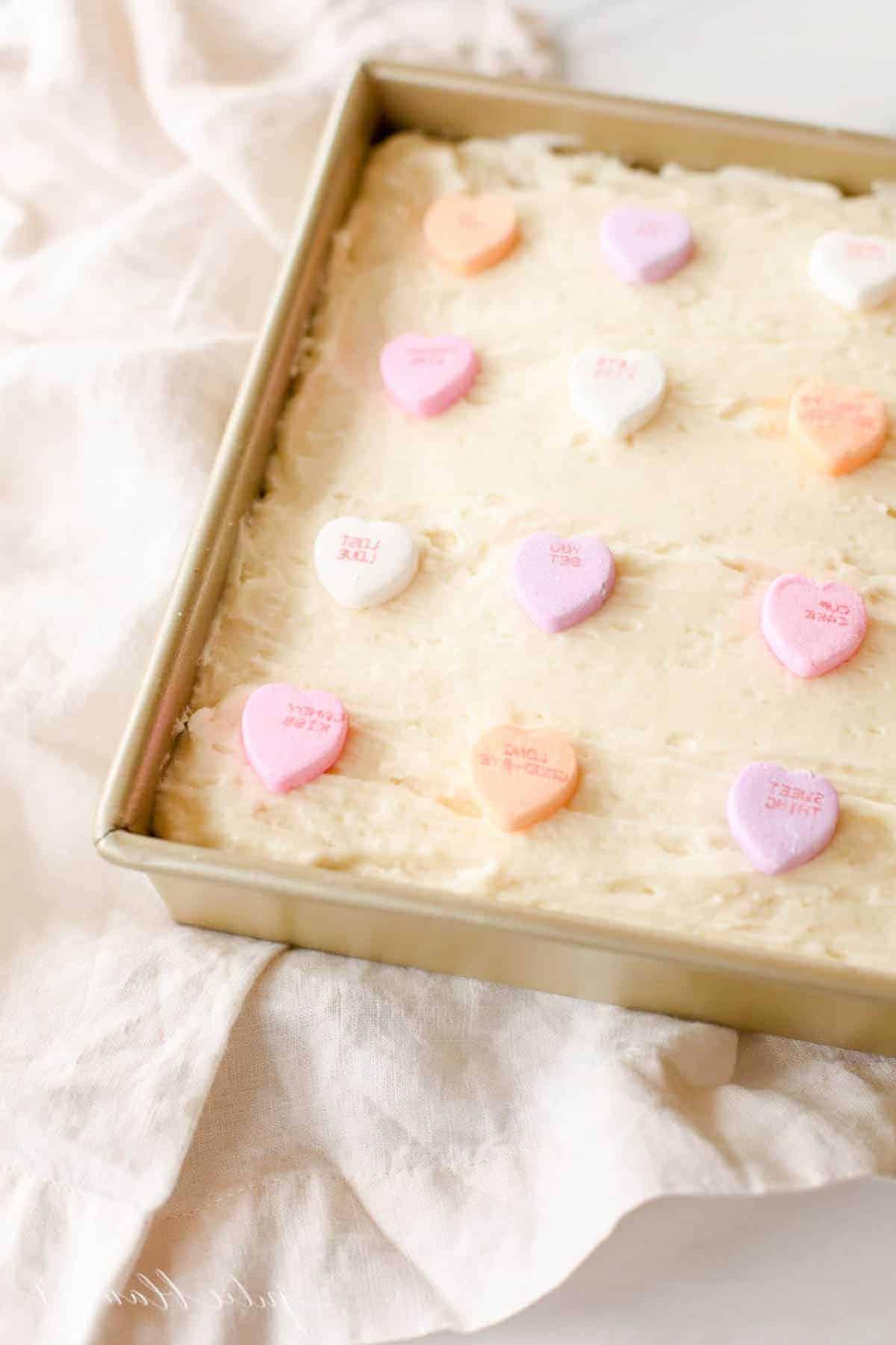 Zuckerkeks-Riegel in goldener Backform, belegt mit bunten Liebesherzen