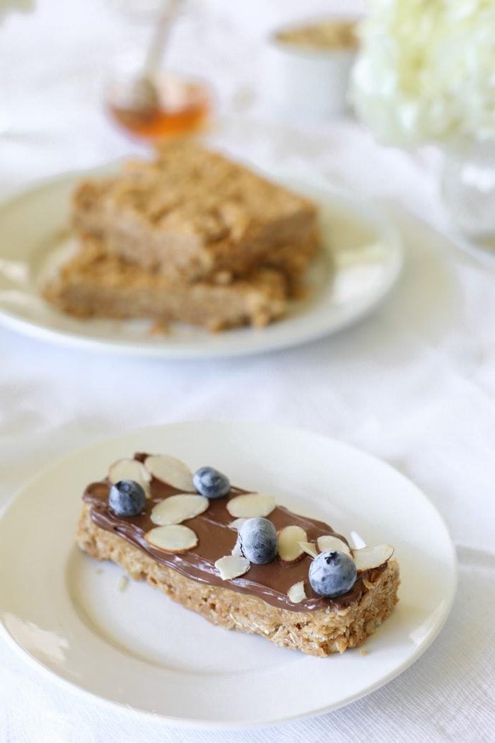 Lernen Sie, wie Sie köstliche Granola Riegel ohne Backen in nur 10 Minuten mit nur 4 Zutaten zubereiten! Diese Erdnussbutter Granola Riegel sind ein köstliches Frühstück! Ein Granola Riegel ohne Backen, garniert mit Schokolade, Früchten und Nüssen.