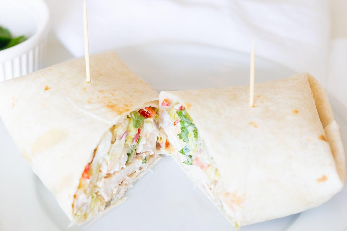 Hähnchen-Wrap-Rezept 2 Ein Hähnchen-Wrap-Rezept auf einem weißen Teller, halbiert.