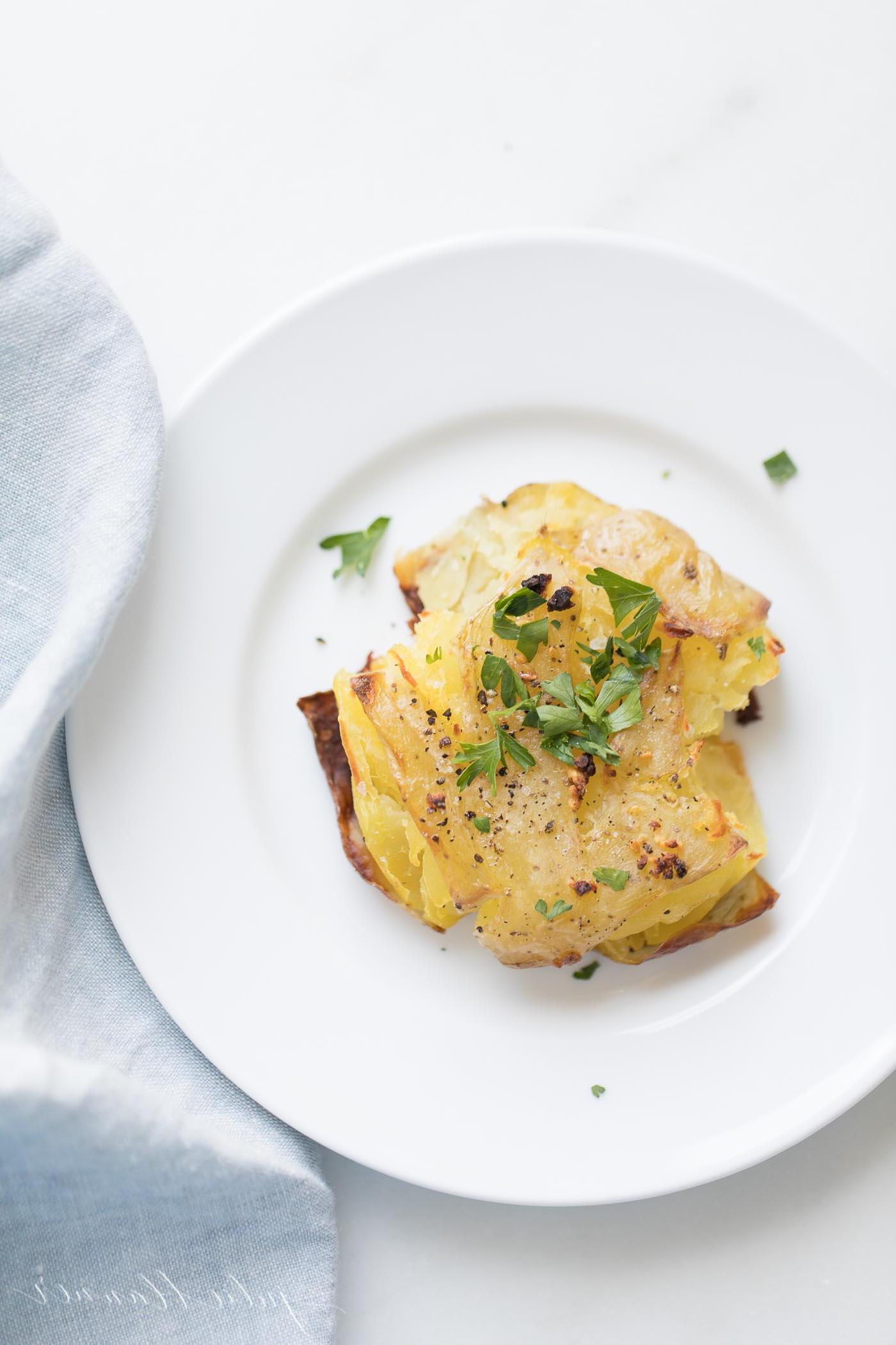 Zerstampfte Knoblauchkartoffeln 2 Knoblauch-Smashed-Potatoes mit Kräutern garniert