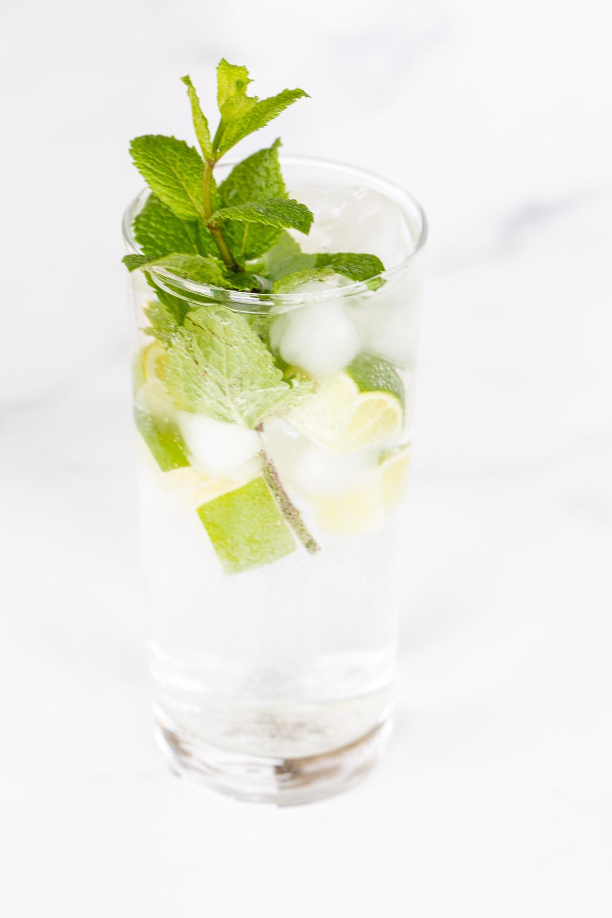 Alkoholfreier Mojito 2 Ein klares Glas voll mit einem Virgin Mojito auf einer Marmoroberfläche.