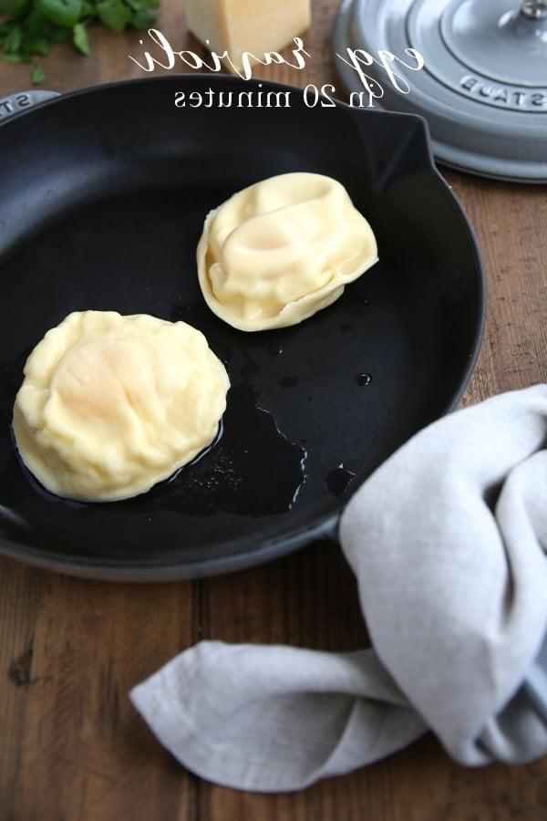 Hausgemachte Eier-Ravioli sind schnell und einfach zuzubereiten und eignen sich hervorragend als Vorspeise oder Hauptgericht. Ravioli gefüllt mit Käse und einem Eigelb, das einfach so beeindruckend ist. Zwei perfekt gekochte Eigelb-Ravioli, präsentiert in einer rustikalen Gusseisenpfanne, bereit zum Servieren und Genießen.