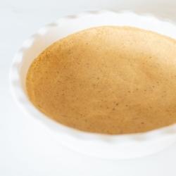 Mürbeteigboden ohne Backen Rezept 8 Ein Shortbread-Kuchenboden, in eine weiße, geriffelte Keramik-Kuchenform auf einer Marmoroberfläche gepresst