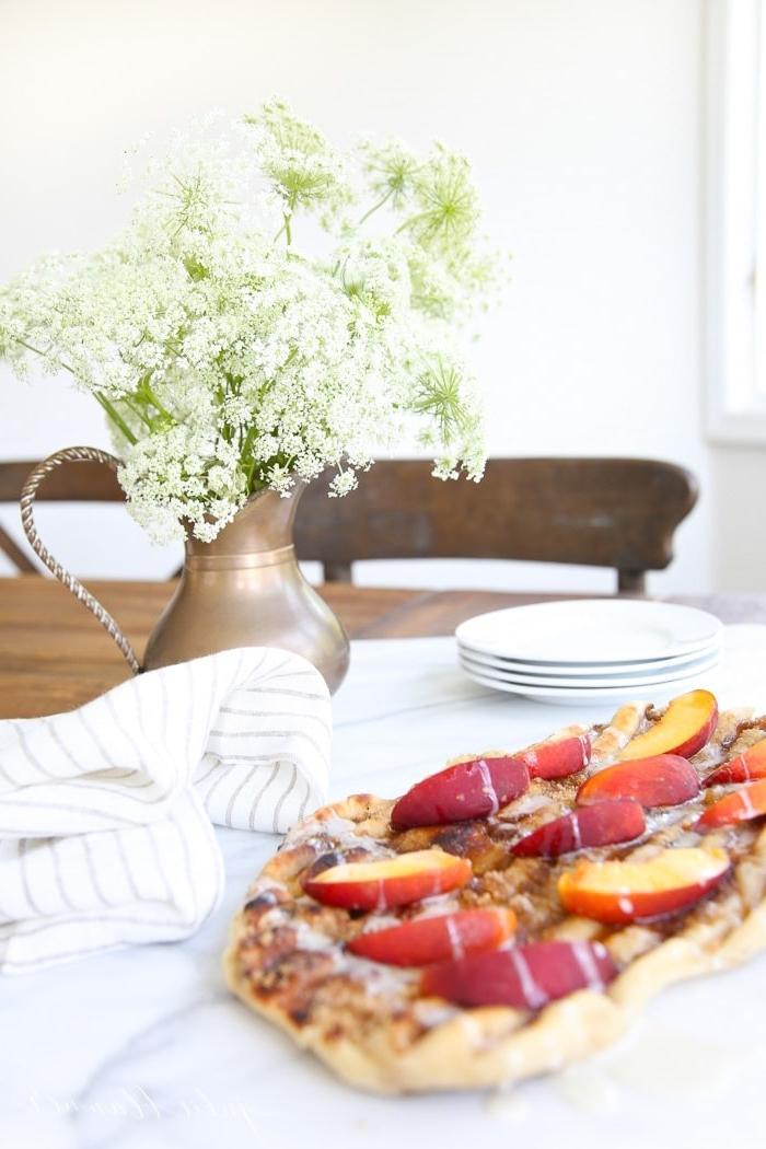 Dessertpizza mit Pfirsichscheiben auf einer weißen Tischdecke