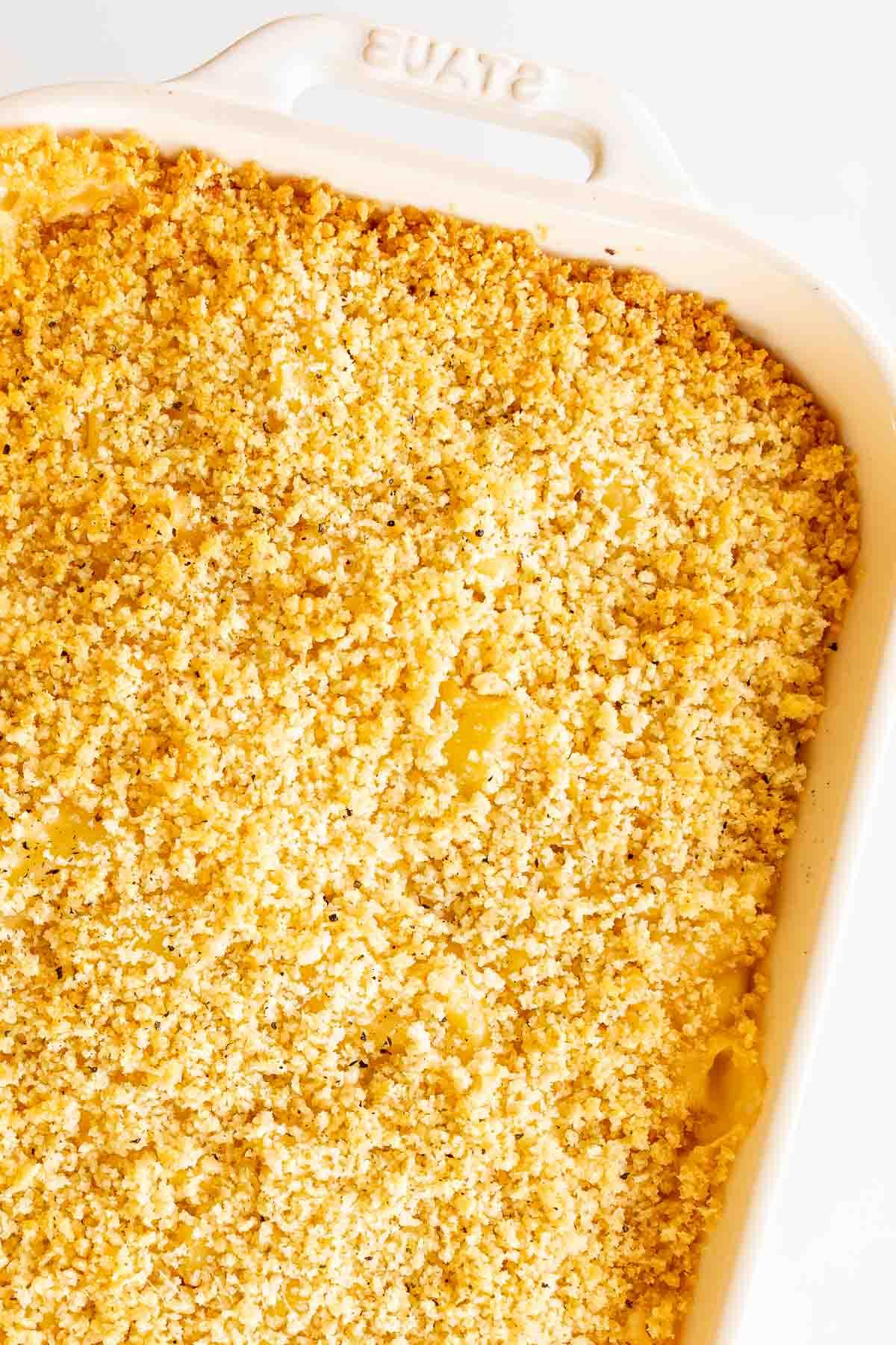 Eine weiße Auflaufform mit einem gebackenen Speck Mac and Cheese Auflauf darin.