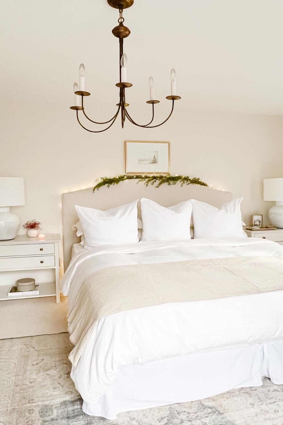 Ein Schlafzimmer, minimalistisch im Weihnachts-Stil mit einer künstlichen grünen Girlande über dem Kopfteil dekoriert.