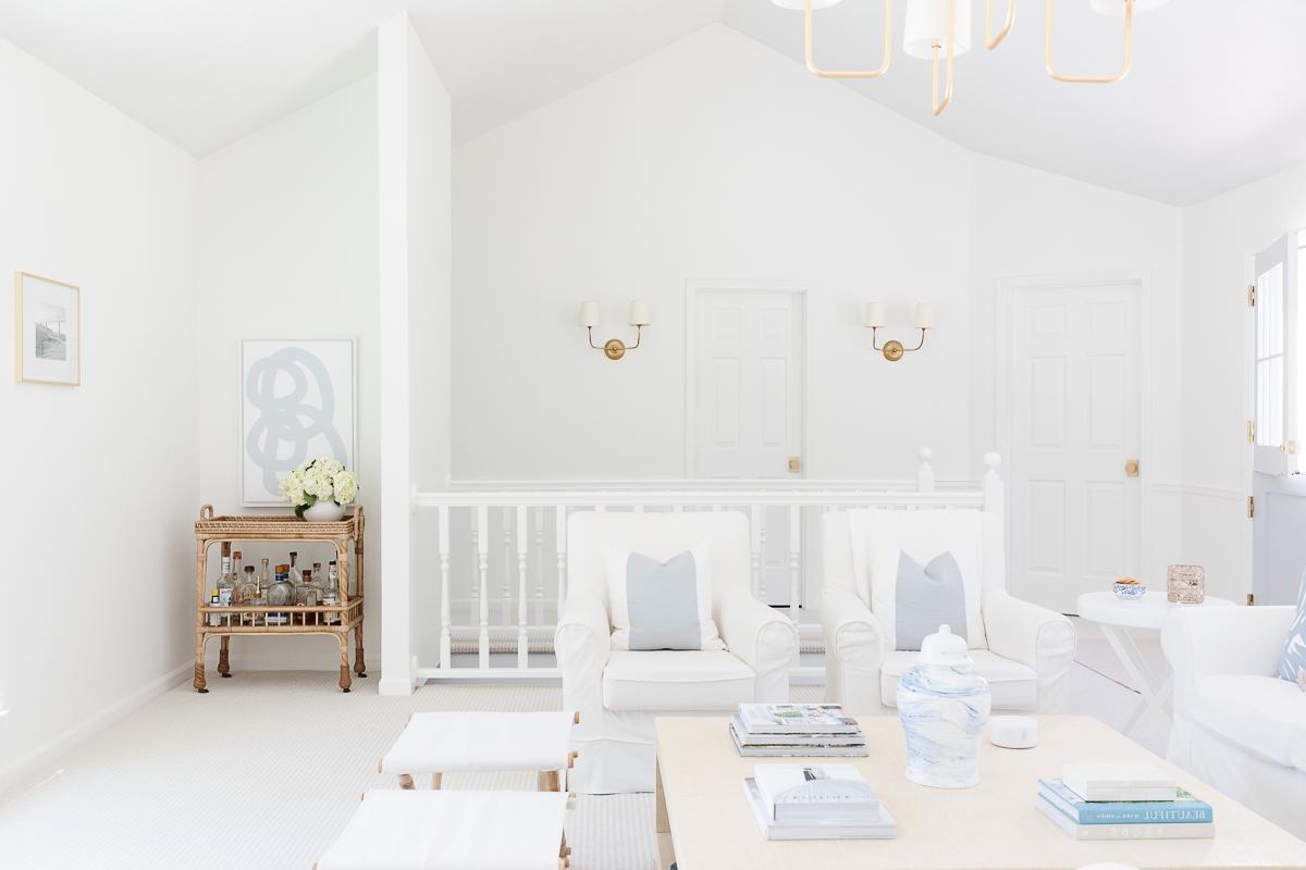 Benjamin Moore Einfach Weiß 12 Ein weißes Wohnzimmer mit blauen Akzenten, Wände gestrichen in Benjamin Moore Simply White.