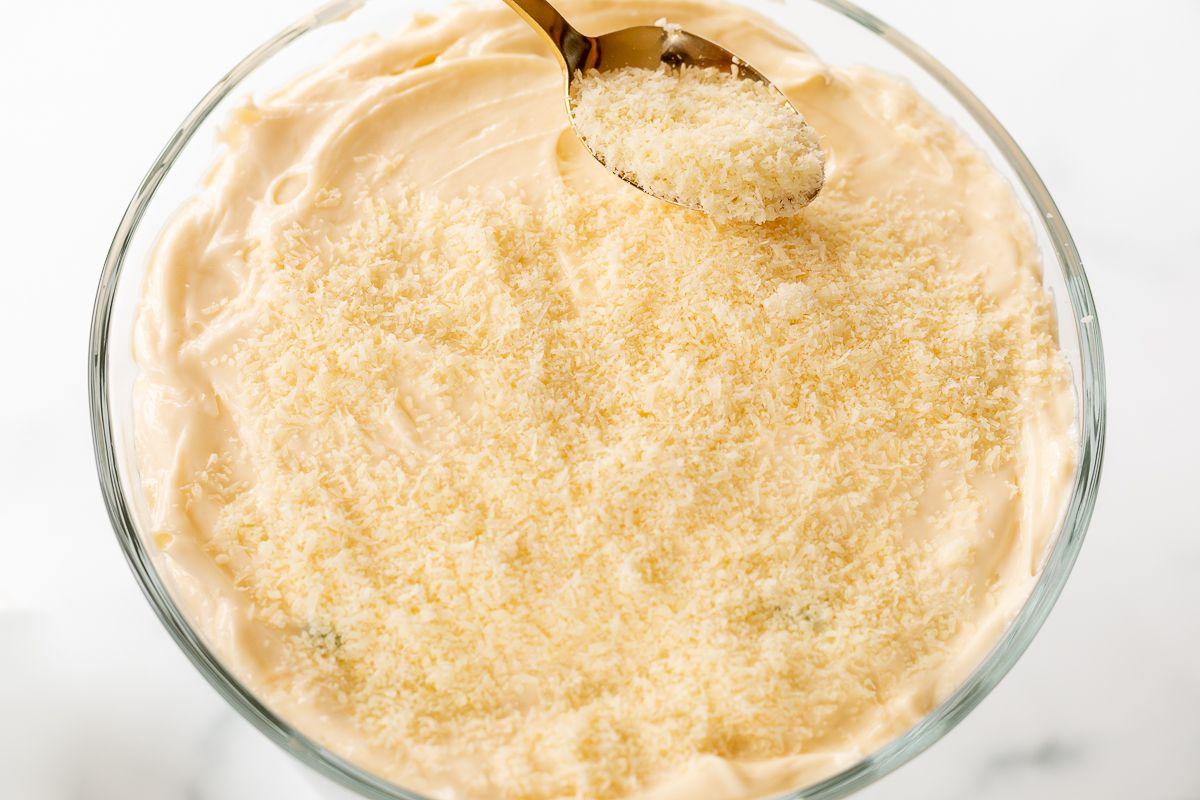 Die Oberseite eines Sieben-Schicht-Salats mit geriebenem Käse bestreut