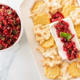 Cranberry-Salsa 12 Ein Teller voller Cracker, die Cranberry-Salsa auf einem Block Frischkäse umgeben