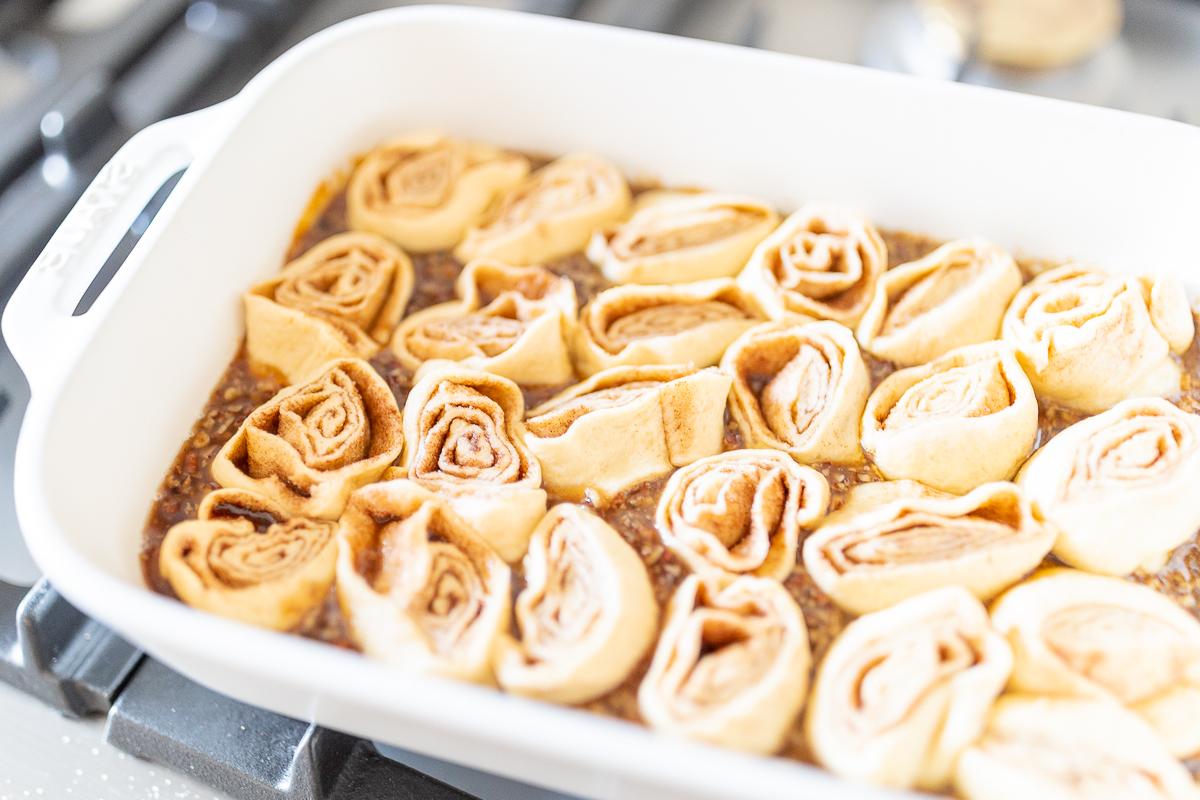 Eine weiße Auflaufform gefüllt mit Pekannussbrötchen.