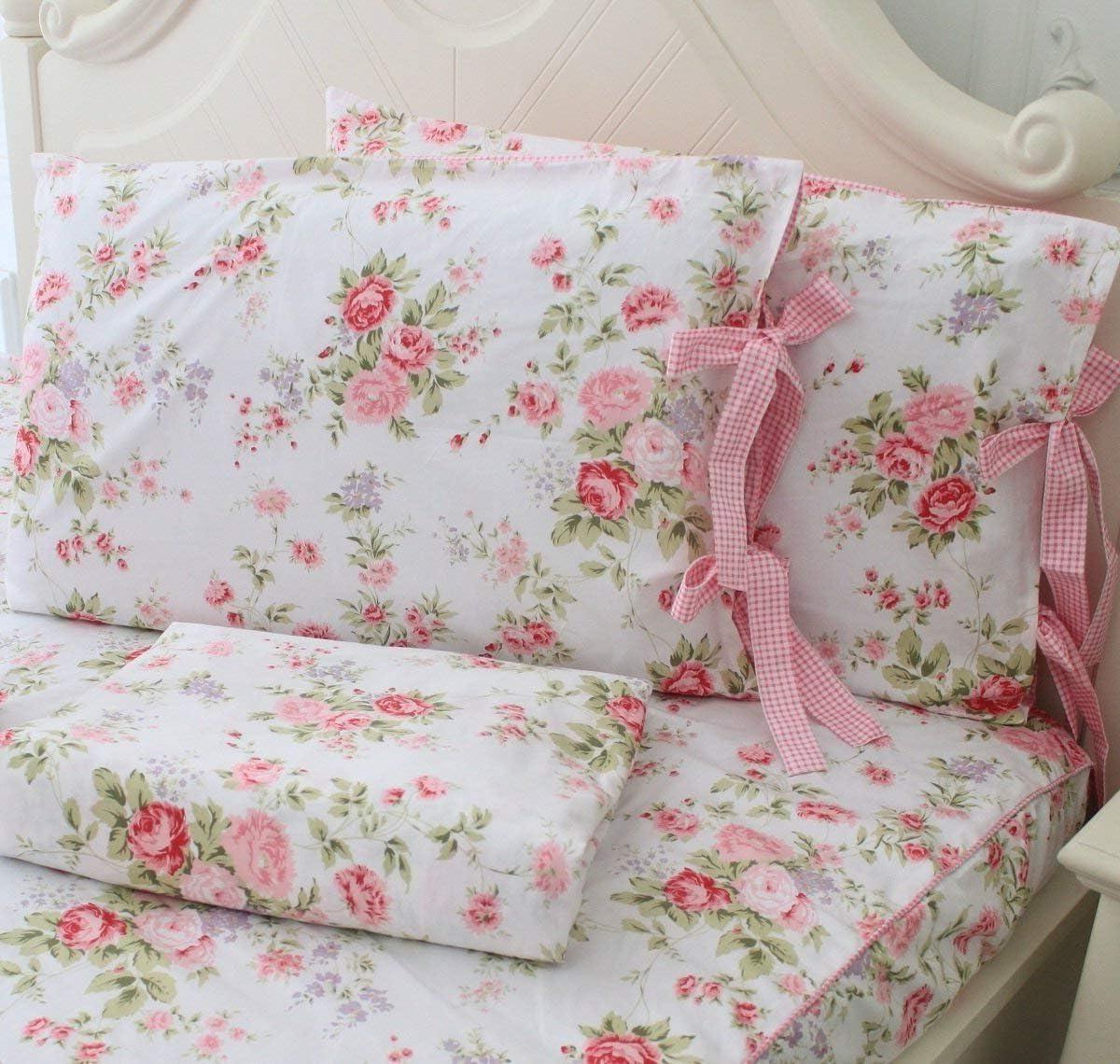 Mädchenetagenbett 13 Ein Set Mädchen-Etagenbetten mit geblümten Laken und Kissen, die mit rosa und roten Blumen verziert sind. Die Kissen haben rosa karierte Bänder an den Seiten.
