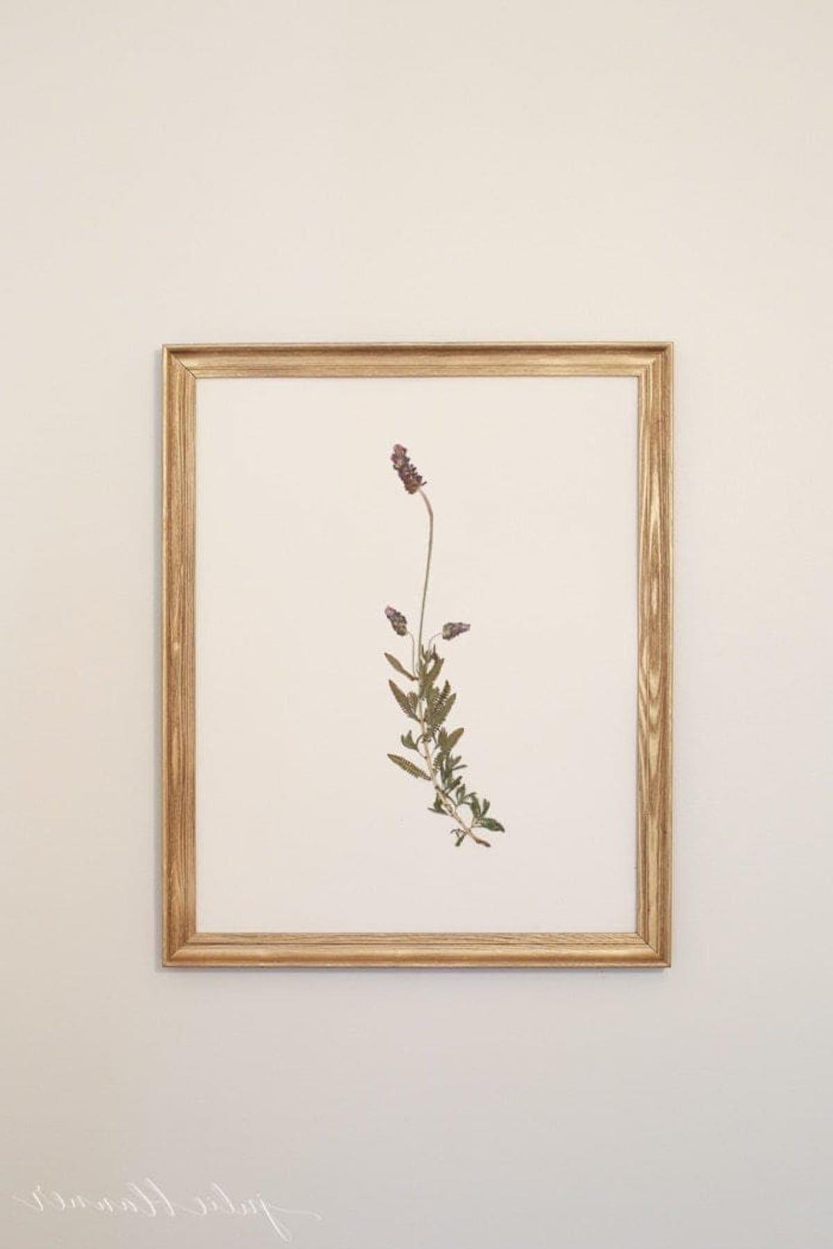 17 Ideen für Kunst über einem Bett 13 Ein kunstvoller Druck einer zarten Blume, der über einem Bett hängt.