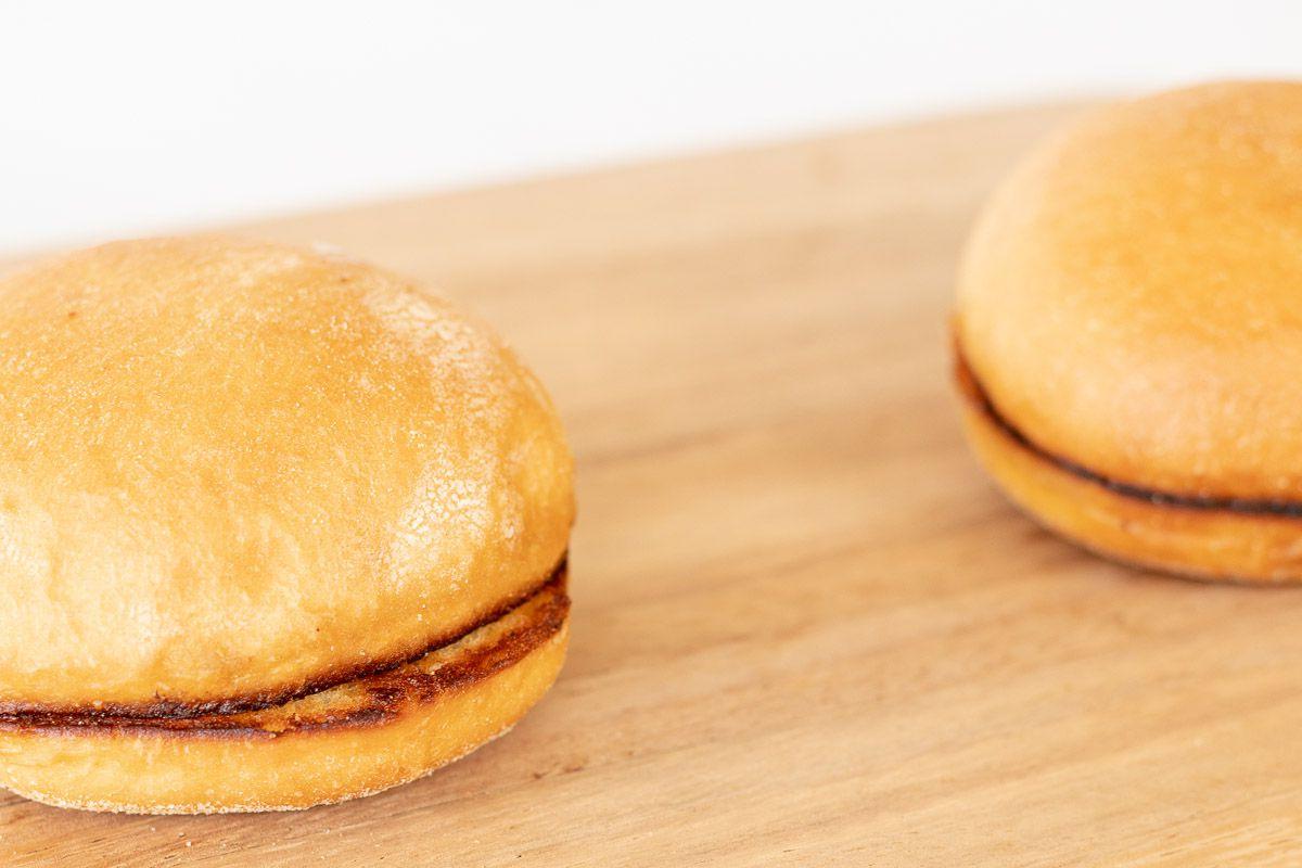 Warum man Burgerbrötchen rösten sollte 13 Ein getoastetes Burger Bun auf einem Holzschneidebrett
