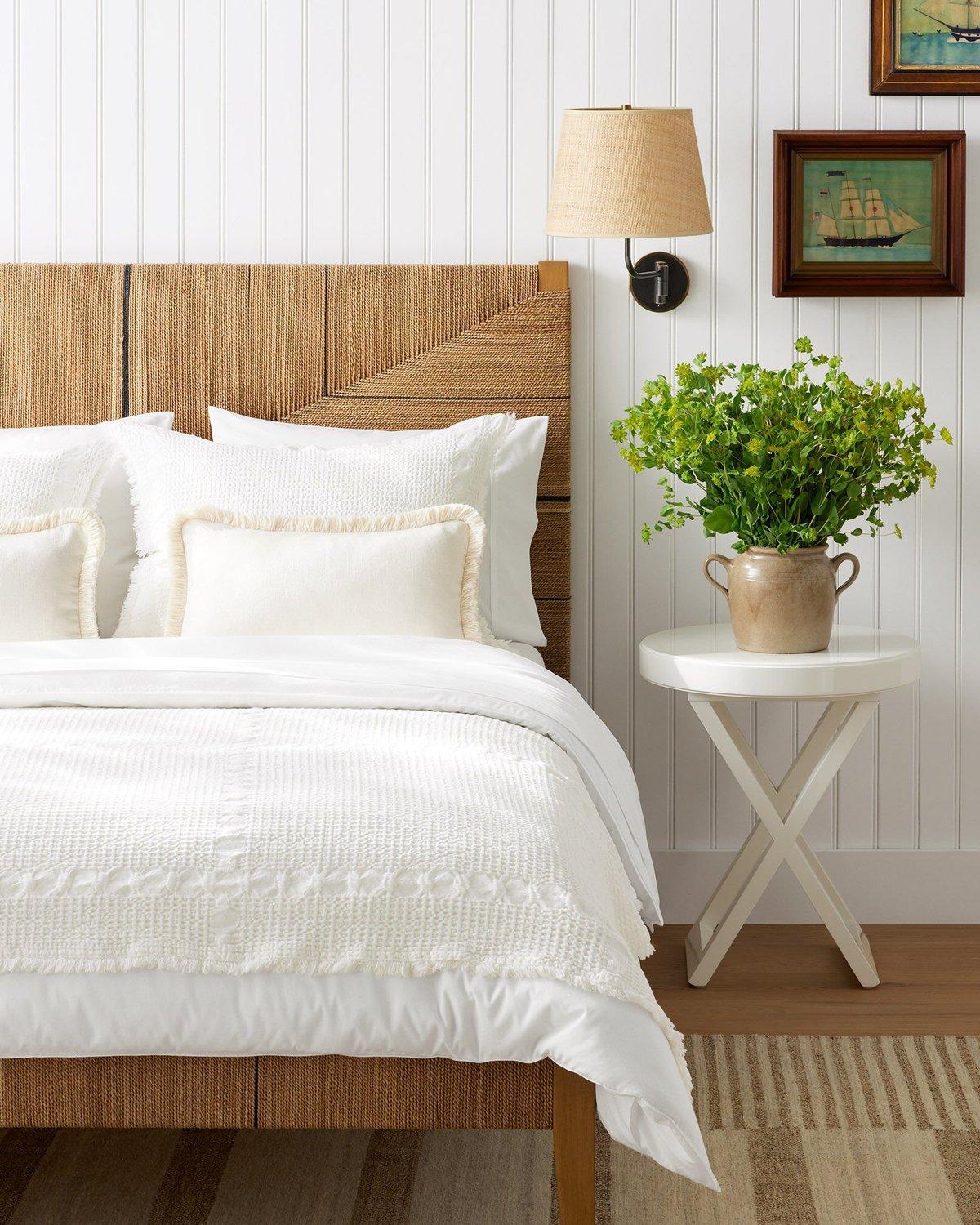 17 Ideen für Kunst über einem Bett 14 Ein Schlafzimmer mit Rattanbett und Beadboard-Wand