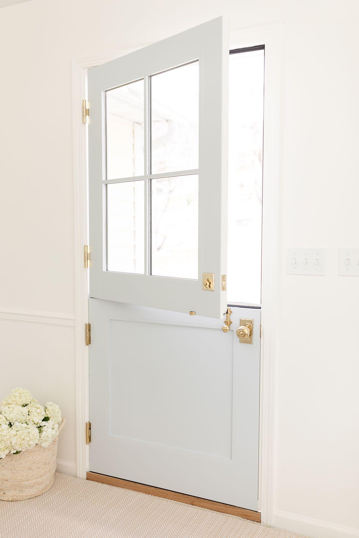 Benjamin Moore Einfach Weiß 15 Ein Eingangsbereich mit Simply White Wänden und einer blauen holländischen Tür.