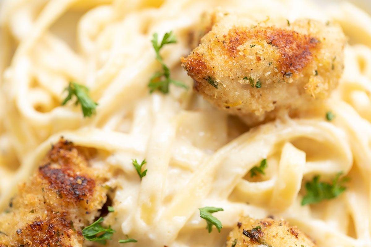 Spießchen 17 Spiedini-Stücke auf einem Bett aus Fettuccine Alfredo.