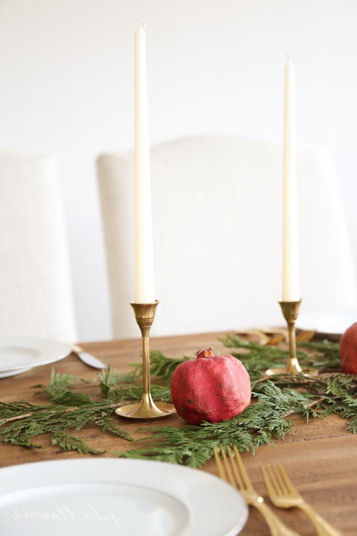 Ein festliches Weihnachts-Kerzen-Mittelstück mit Granatäpfeln.