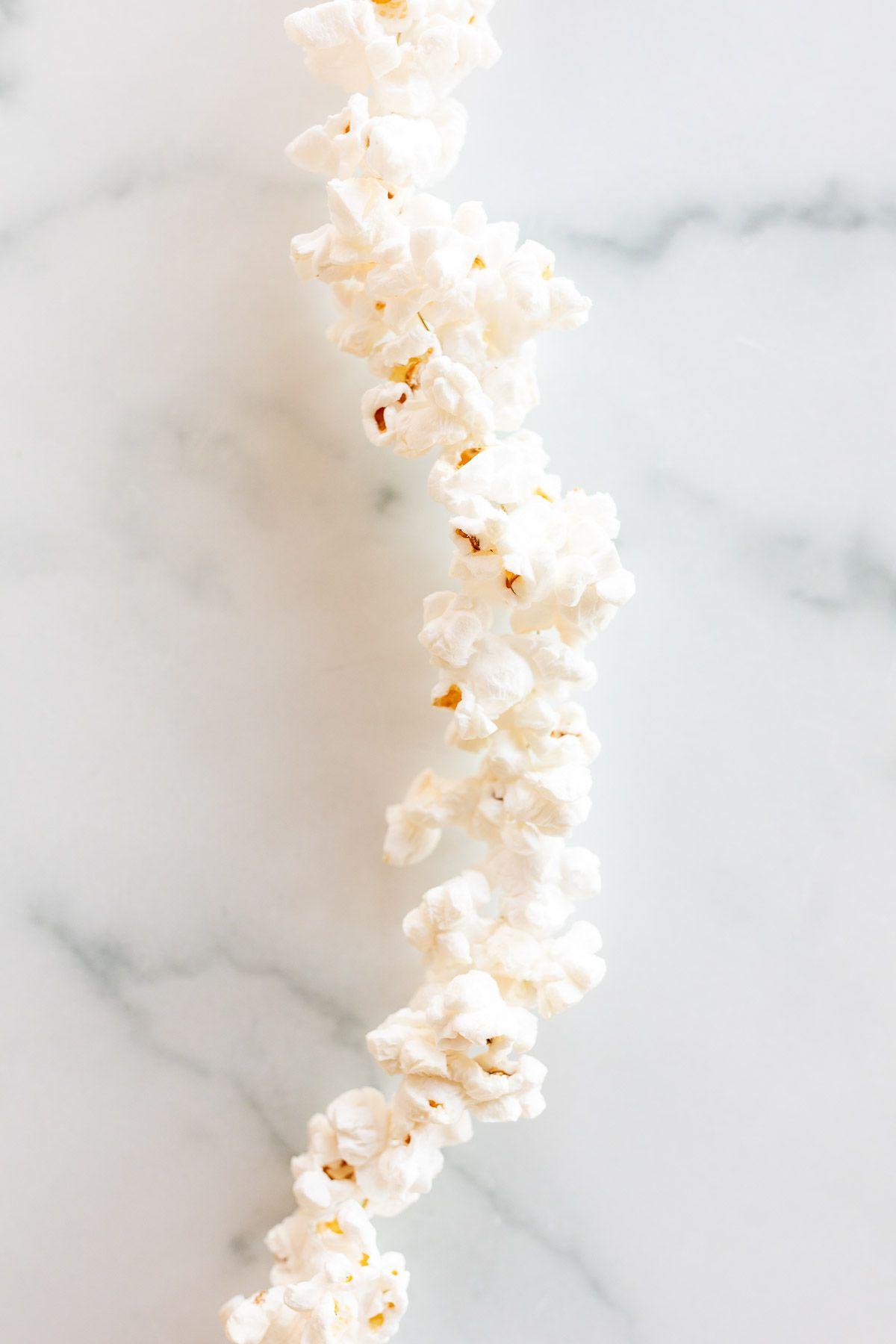 Eine Popcorn-Girlande auf einer weißen Marmoroberfläche.