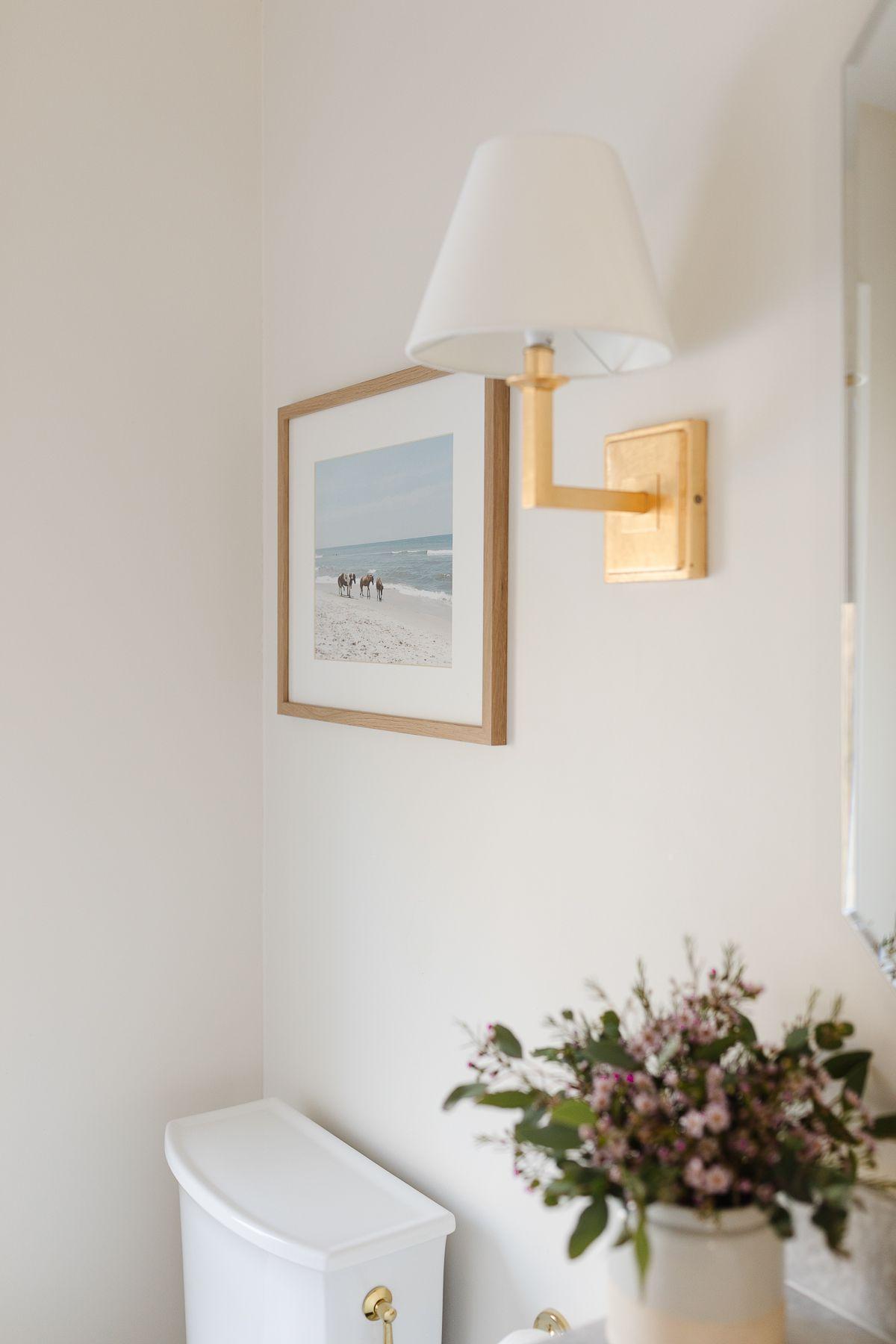 So erstellen Sie ein Spa-Bad zu Hause 19 Ein Heims-Spa-Bad mit einem Foto von Wildpferden am Strand an der Wand, das eine beruhigende Naturkulisse bietet.