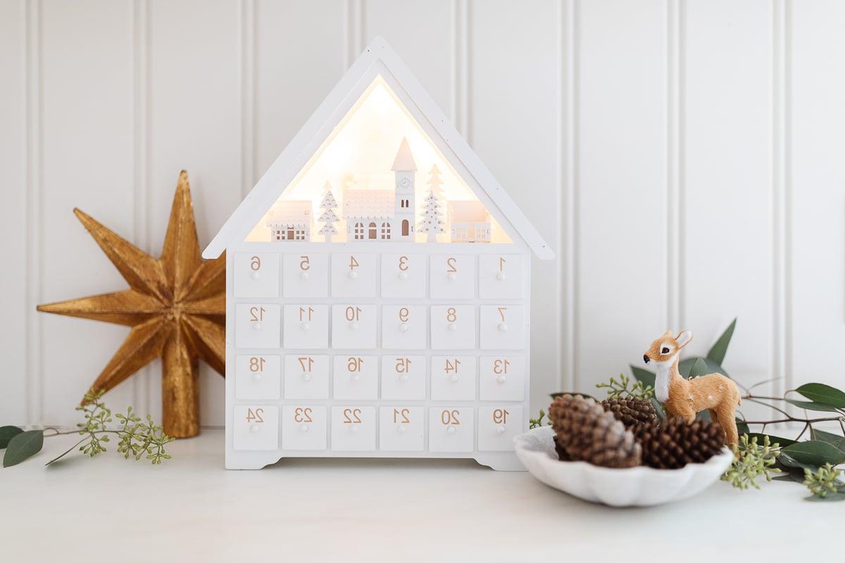 Adventskalender umgeben von Weihnachtsdeko.