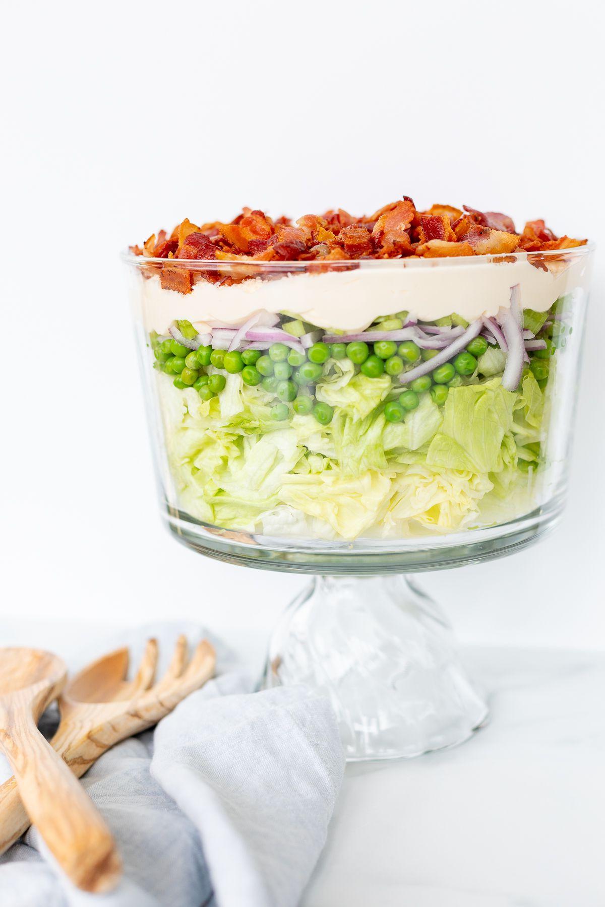 Siebenschichtsalat 3 Sieben-Schicht-Salat mit Speck belegt auf einer Marmorarbeitsplatte