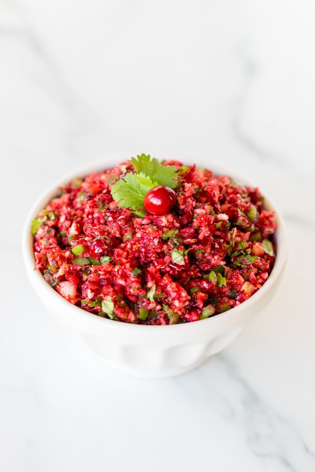 Cranberry-Salsa 3 Eine weiße Schüssel voll Cranberry-Salsa auf einer Marmoroberfläche