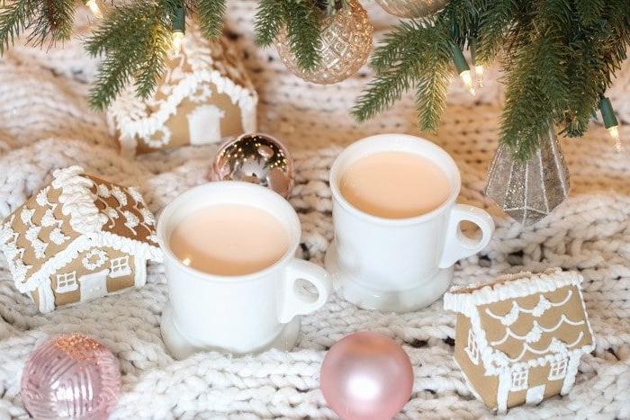 Fantasievolles Rezept für rosafarbene heiße Schokolade, das Kinder lieben werden Zwei Tassen rosafarbener heißer Schokolade unter einem Weihnachtsbaum
