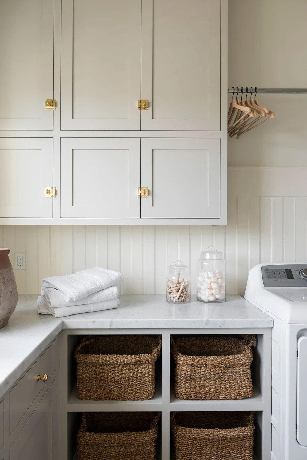 Benjamin Moore Revere Pewter 3 Eine Waschküche mit in Benjamin Moore Revere Pewter gestrichenen Schränken.