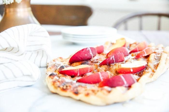Eine Dessertpizza mit Pfirsichscheiben auf einer weißen Tischdecke