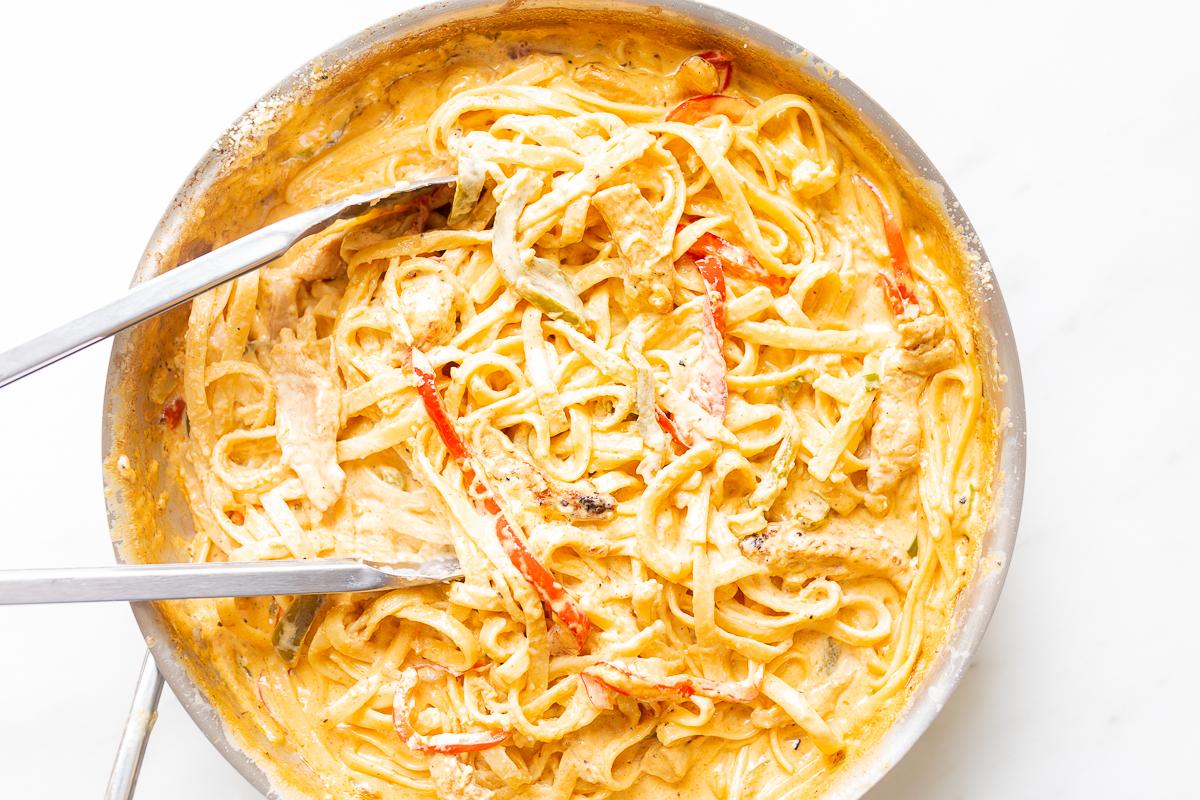 Wie man Nudeln aufwärmt 3 Ein Edelstahlkochtopf auf einem Herd, gefüllt mit Pasta. Das Bild ist Teil eines Tutorials zum Aufwärmen von Pasta.