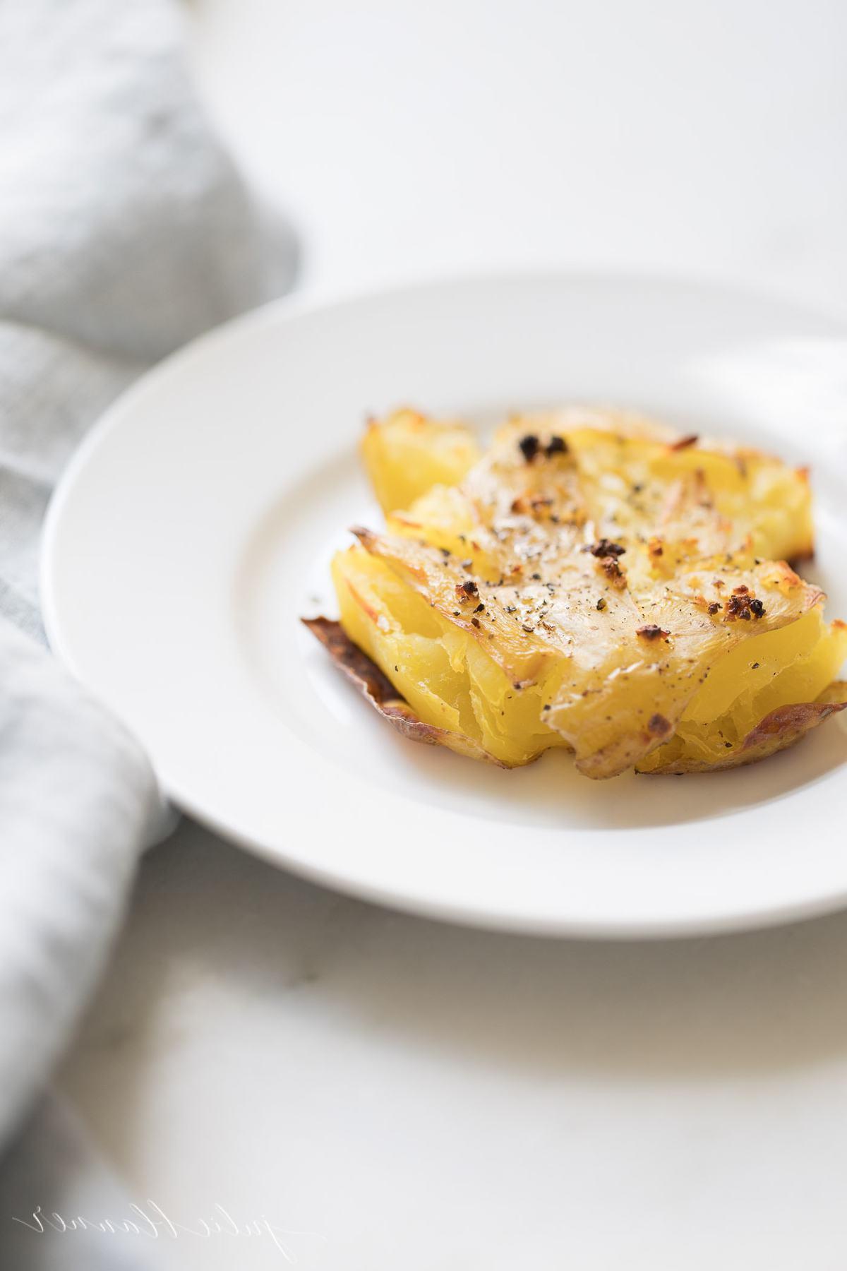 Zerstampfte Knoblauchkartoffeln 3 Knoblauch-Smashed-Potatoes auf einem Teller