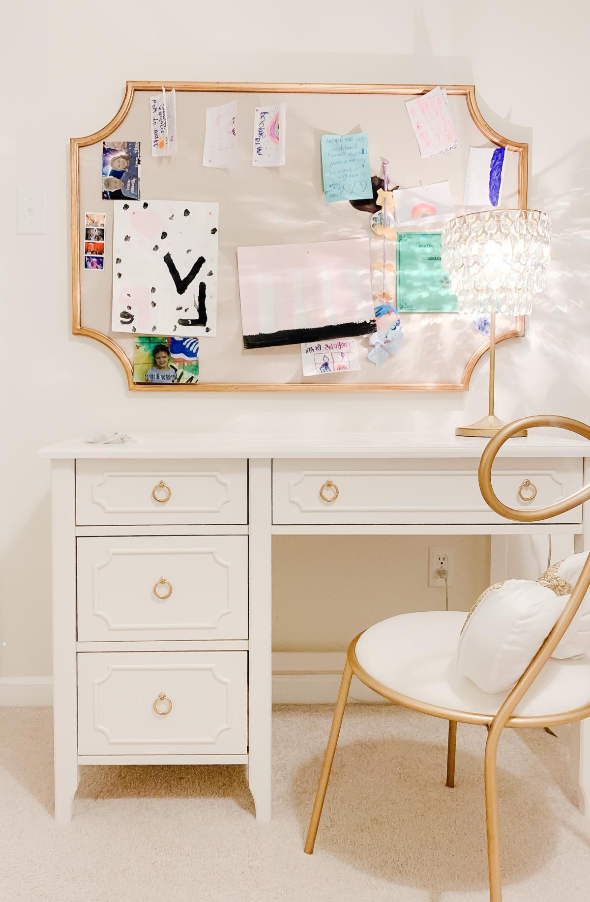 Pottery Barn Kids: Der Look zum kleinen Preis 30 Ein weißer Schreibtisch mit einem goldenen Spiegel und Stuhl, ein elegantes Arrangement im Stil von Pottery Barn Kids.