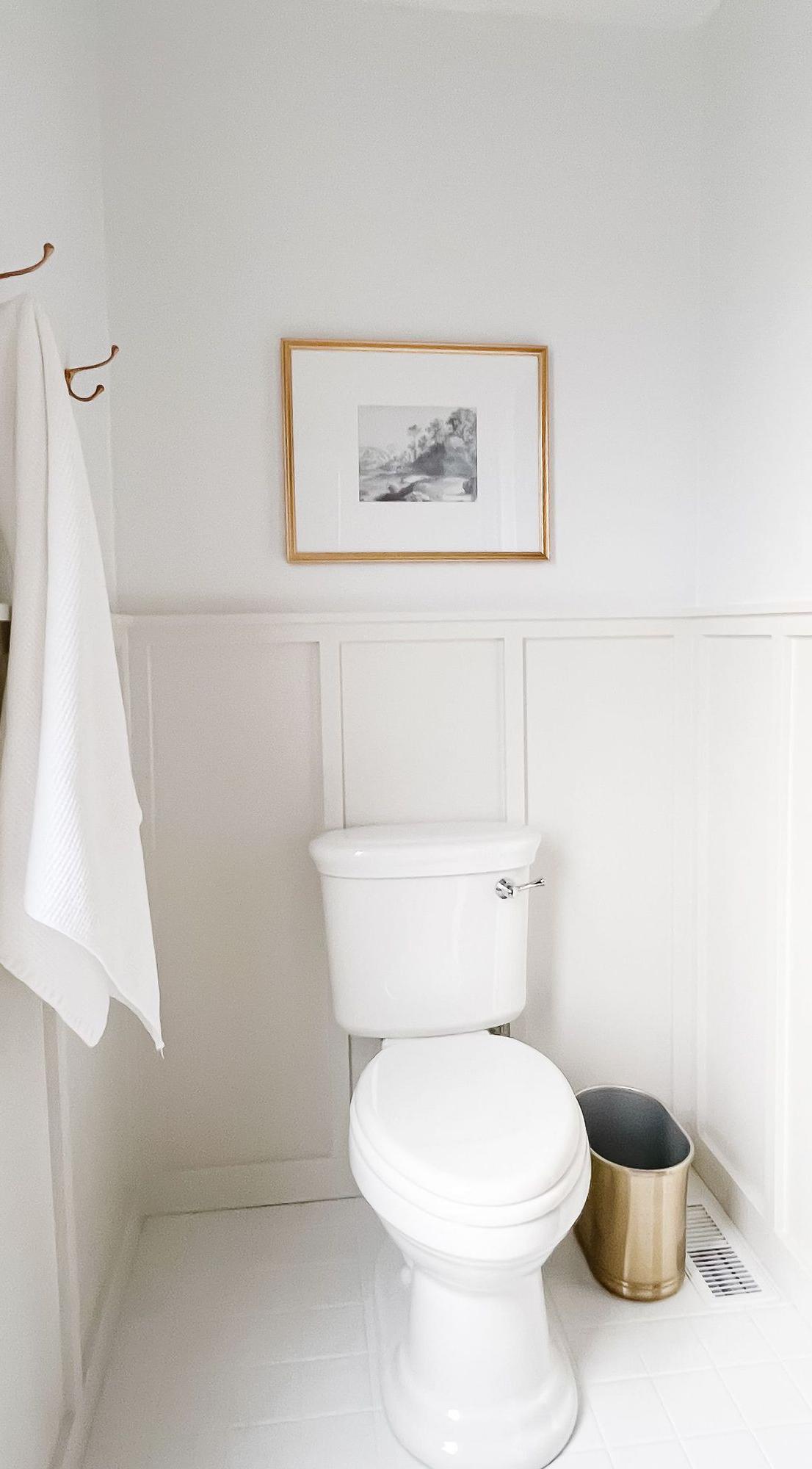 Benjamin Moore Dekorateur-Weiß 4 Ein weißes und graues Badezimmer mit Täfelung und darüberliegender Decorator's White Farbe.