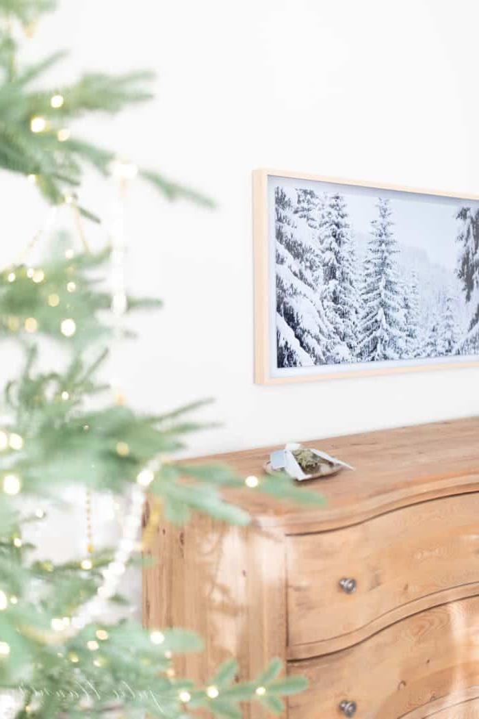 **Wo man Kunst für den Samsung The Frame TV kaufen kann** 4 Weihnachtliche Schlafzimmerdekoration mit einem schönen Baum, einer weichen Holzkommode und einem Kunst-TV.