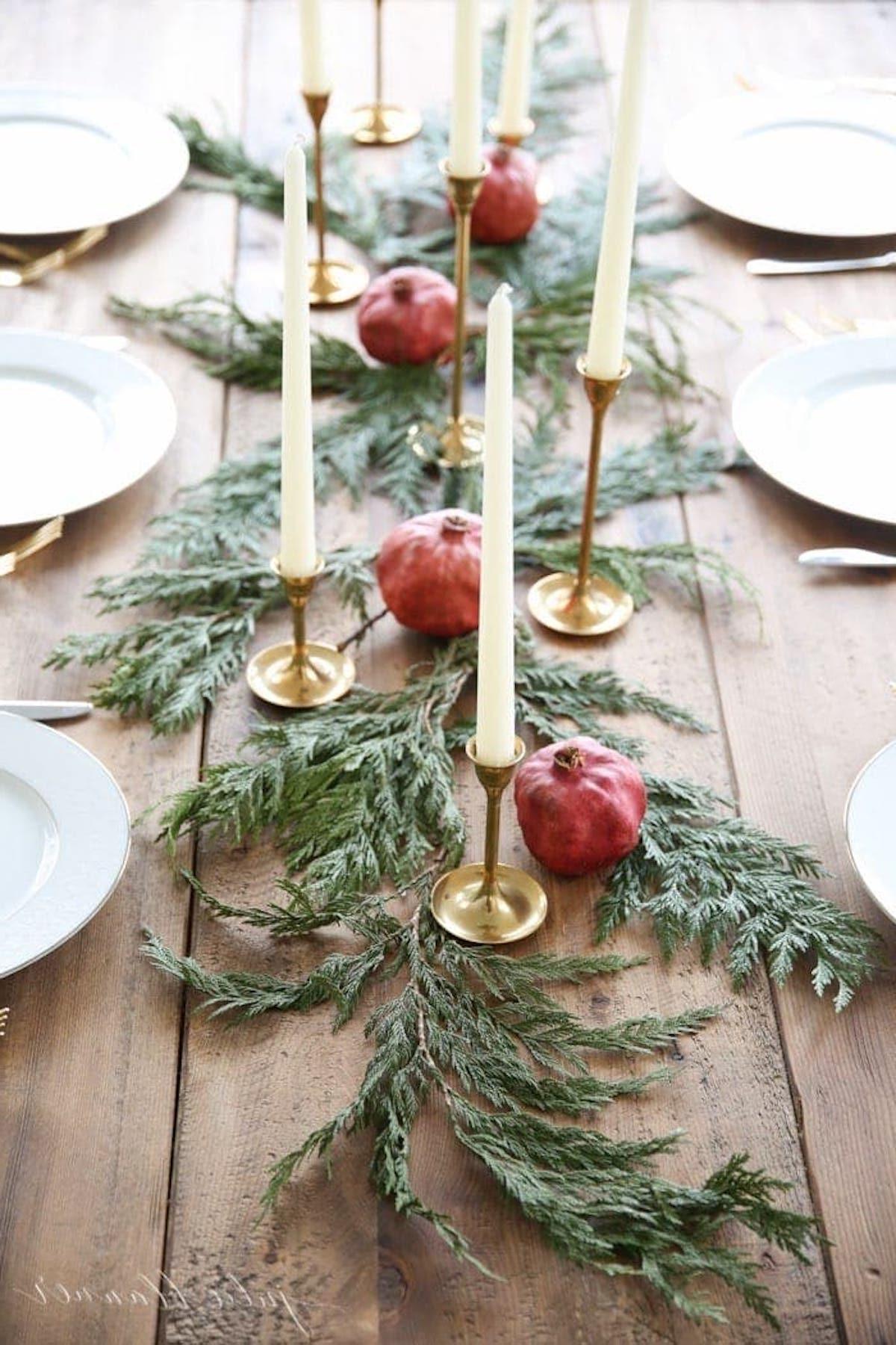 Festlicher Weihnachtstischläufer, geschmückt mit Granatäpfeln und Grünzeug, perfekt für die Gestaltung eines eleganten Mittelstücks.