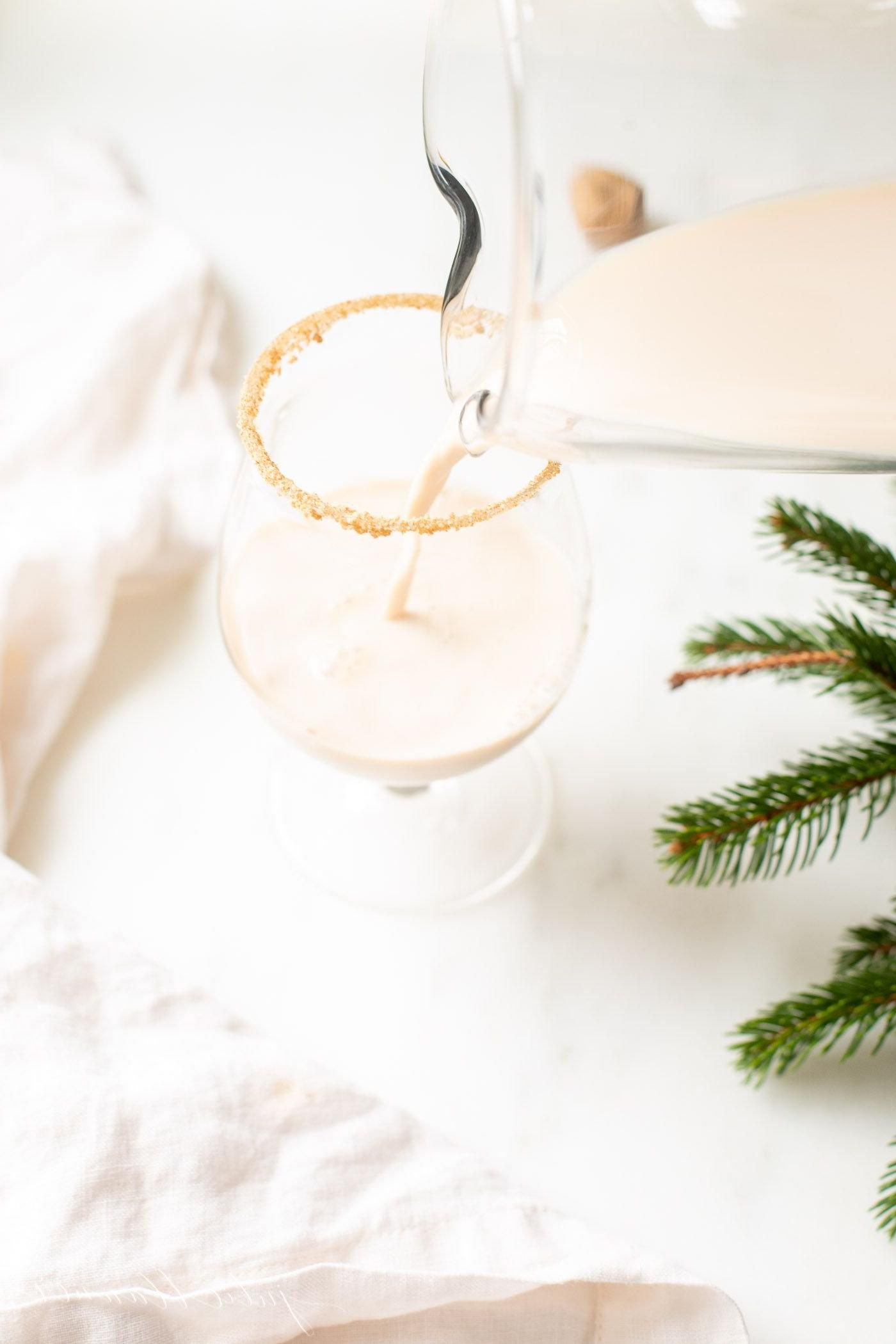 Haferflockenkeks-Cocktail 4 Ein klares Glas mit einem Haferflockenkeks-Cocktail, frisches Wintergrün am Bildrand.