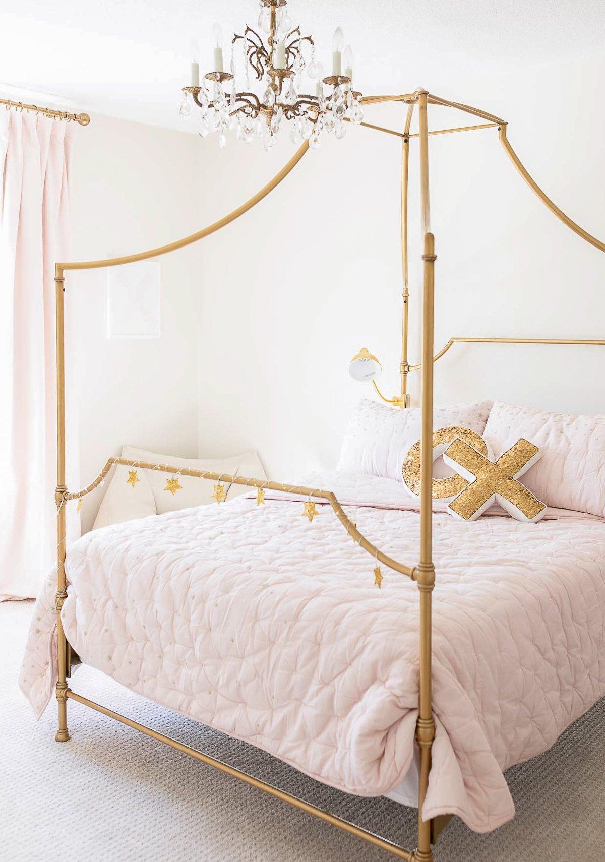 Pottery Barn Kids: Der Look zum kleinen Preis 4 Ein stilvolles Schlafzimmer mit einem eleganten Himmelbett aus Gold und passender pinker Bettwäsche, die den luxuriösen Pottery Barn Kids Look for Less verkörpert.