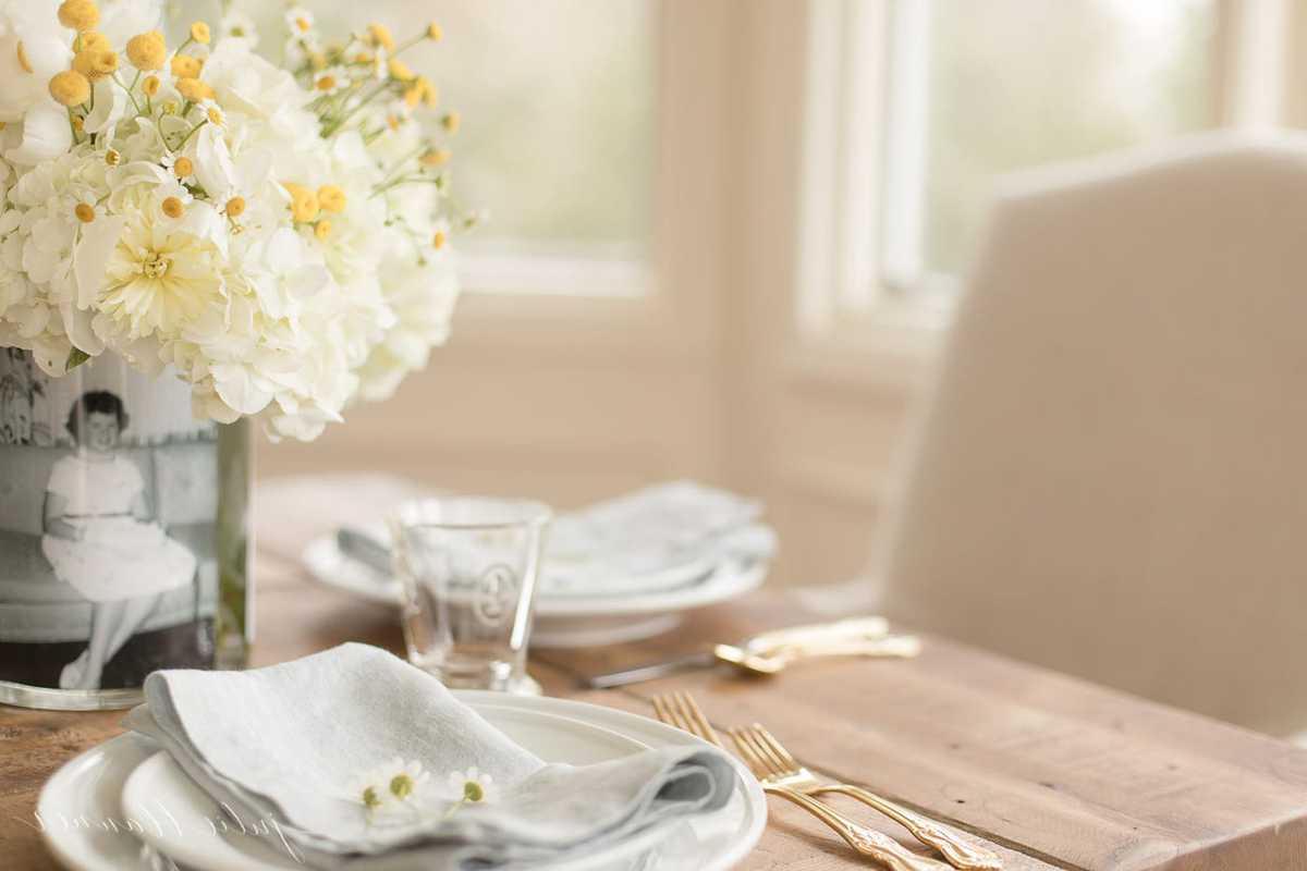 Muttertags-Fotovase 4 Muttertags-Tischdekoration: Eine Vase voller Blumen mit einem Vintage-Foto auf einem für den Brunch gedeckten Tisch.