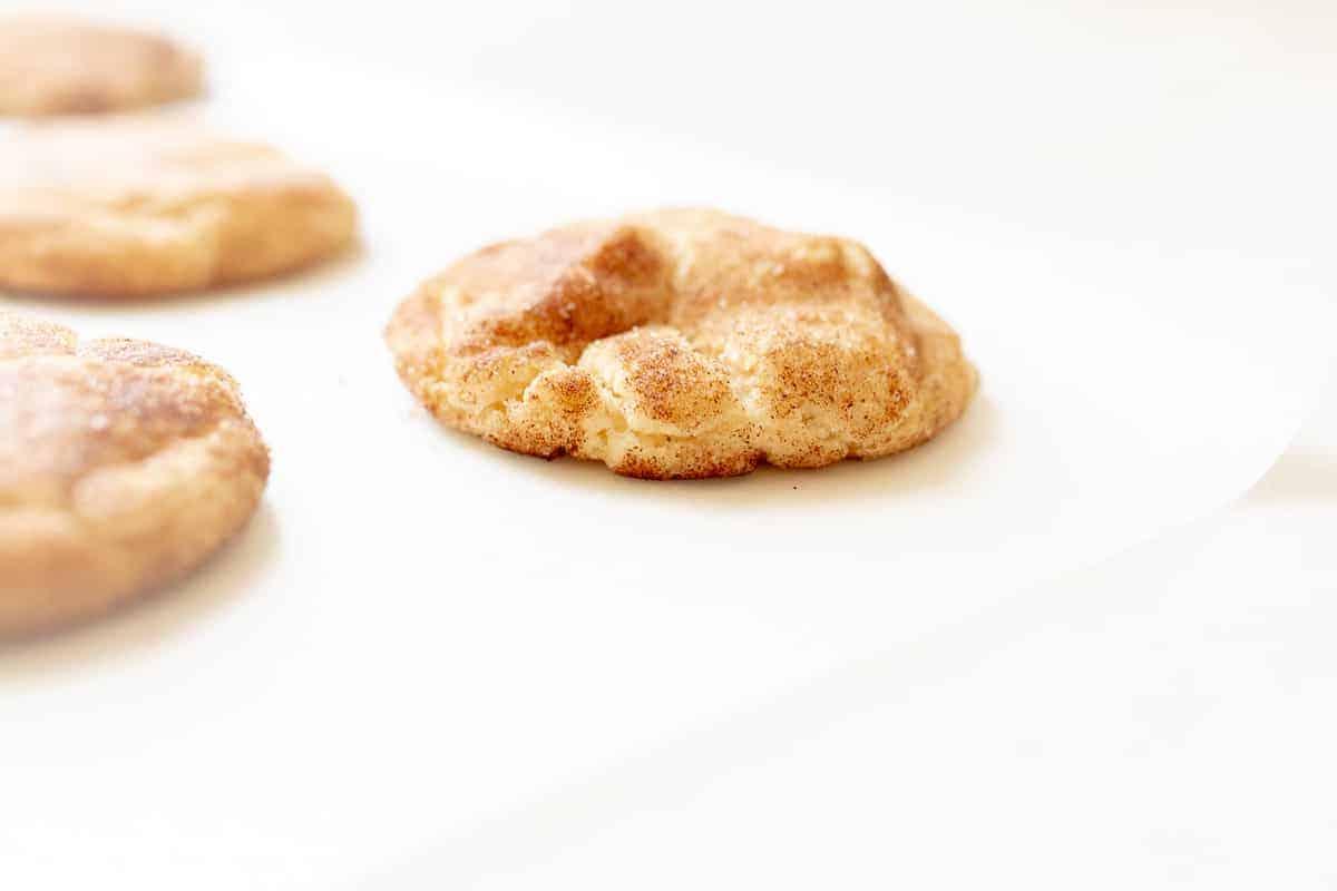 Die besten weichen Snickerdoodles 4 Ein Snickerdoodle-Keks auf einer weißen Oberfläche.