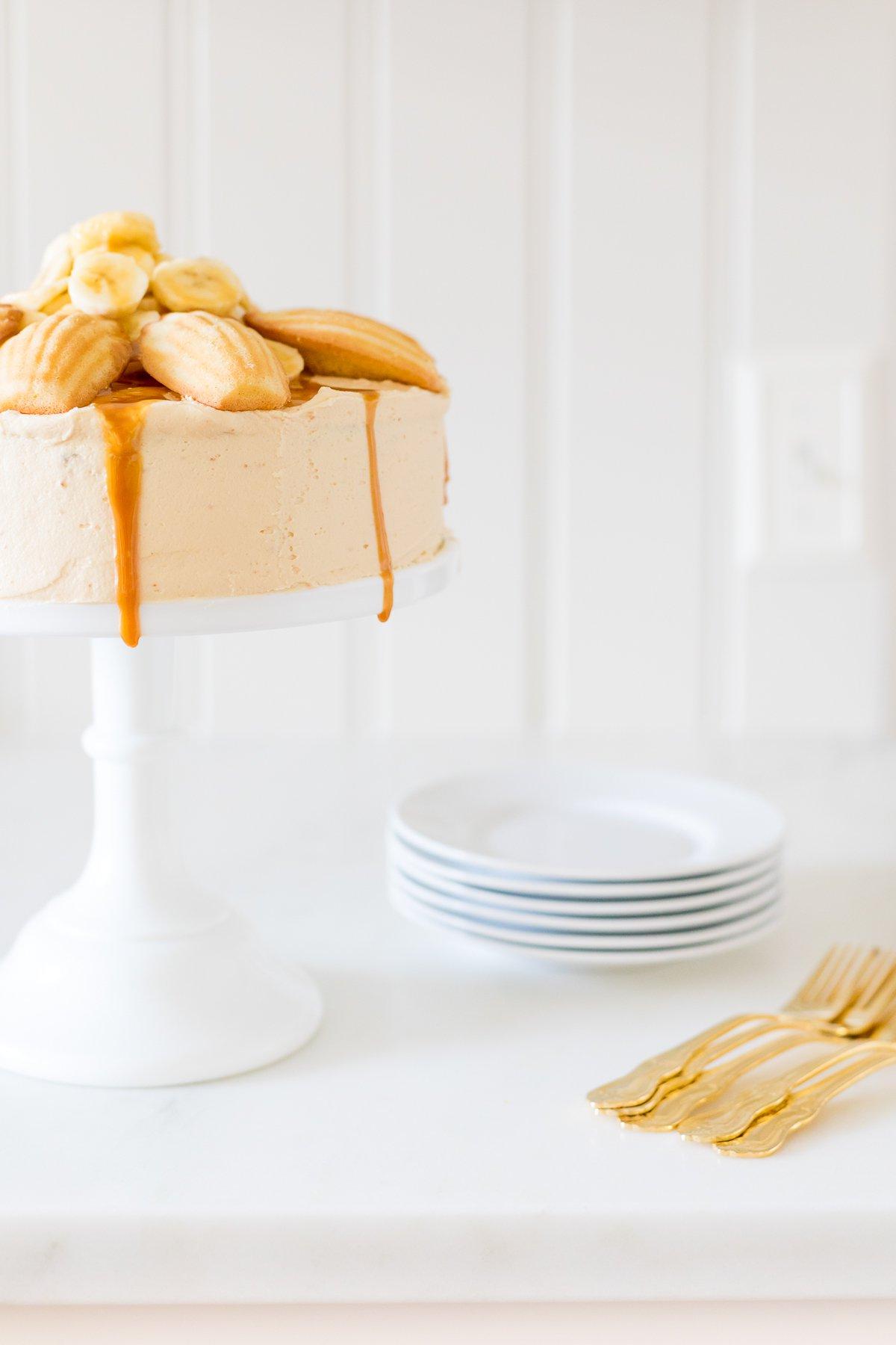 Bananenrezepte 4 Ein runder Bananenkuchen, belegt mit Madeleine-Keksen und Karamellsauce.