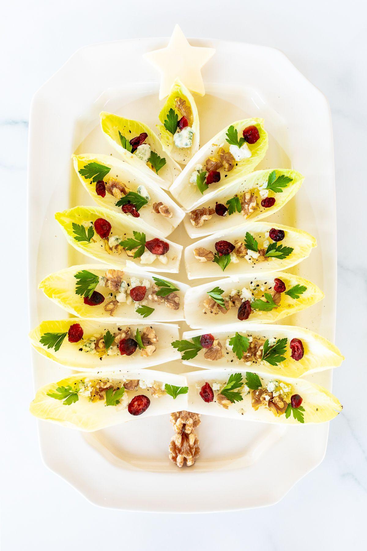 Hand-Endiviensalat 4 Ein Chicorée-Salat in Form eines Weihnachtsbaums auf einer weißen Platte angerichtet.