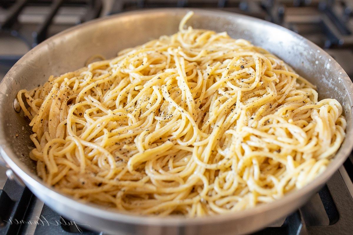 Wie man Nudeln aufwärmt 4 Ein Edelstahlkochtopf auf einem Herd, gefüllt mit Pasta. Das Bild ist Teil eines Tutorials zum Aufwärmen von Pasta.