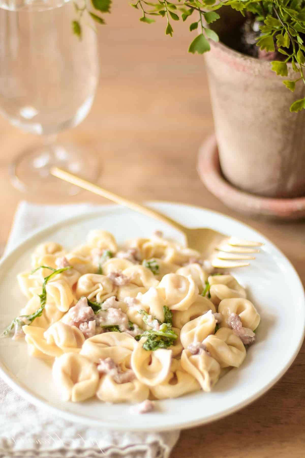 Maggiano's Tortellacci auf einem weißen Teller mit goldener Gabel auf einer Leinen-Serviette