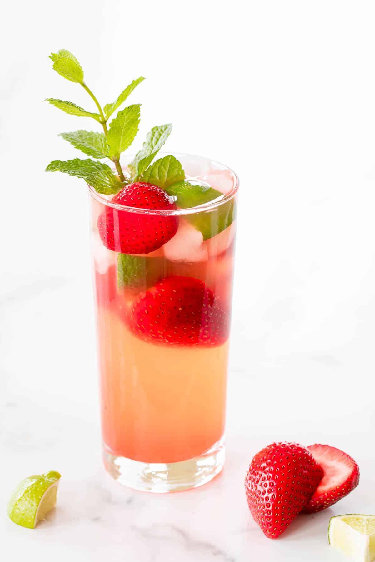 Muttertags-Brunch-Ideen 31 Erdbeer-Mojito in einem klaren Cocktailglas, garniert mit Minze und Limettenspalten