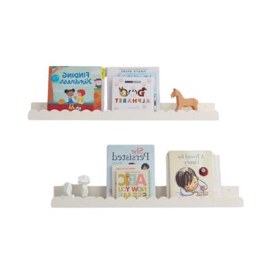 Pottery Barn Kids: Der Look zum kleinen Preis 33 Ein weißes Regal mit Büchern und Spielzeug, das den organisierten und stilvollen Look von Pottery Barn Kids widerspiegelt.