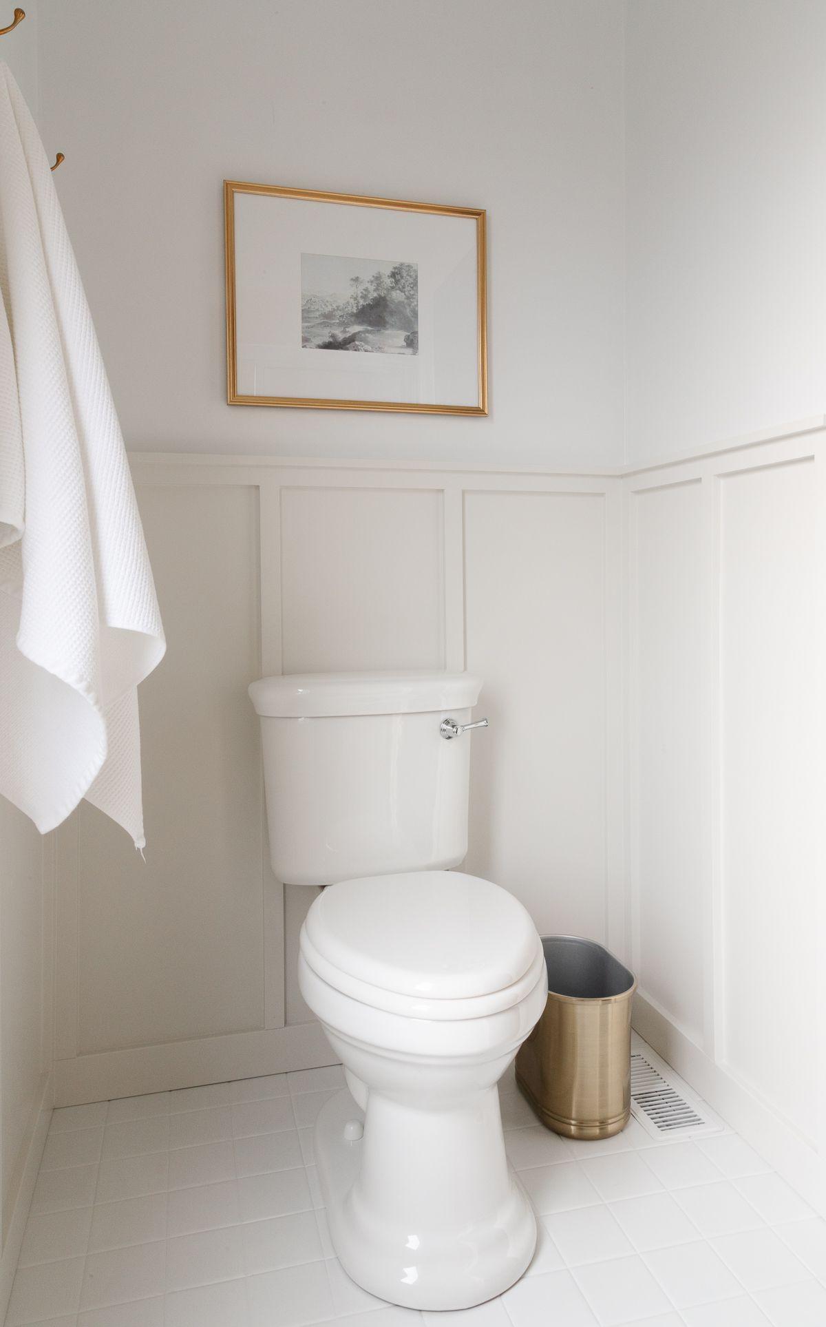 Benjamin Moore Dekorateur-Weiß 5 Ein weißes und graues Badezimmer mit Täfelung und darüberliegender Benjamin Moore Decorator's White Farbe.